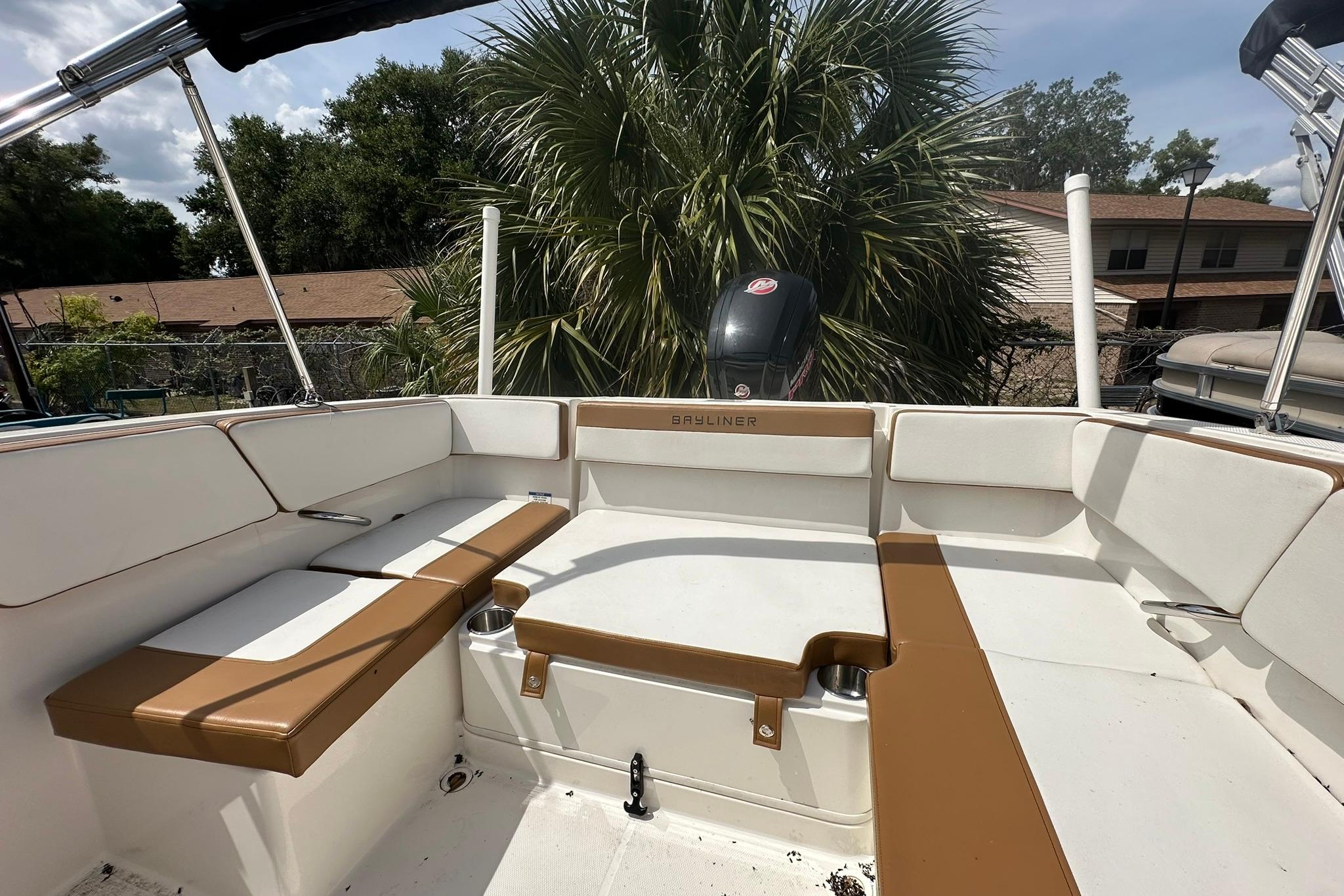 2019 Bayliner VR4 Bowrider OB interior with tan and white seating, outdoor setting.