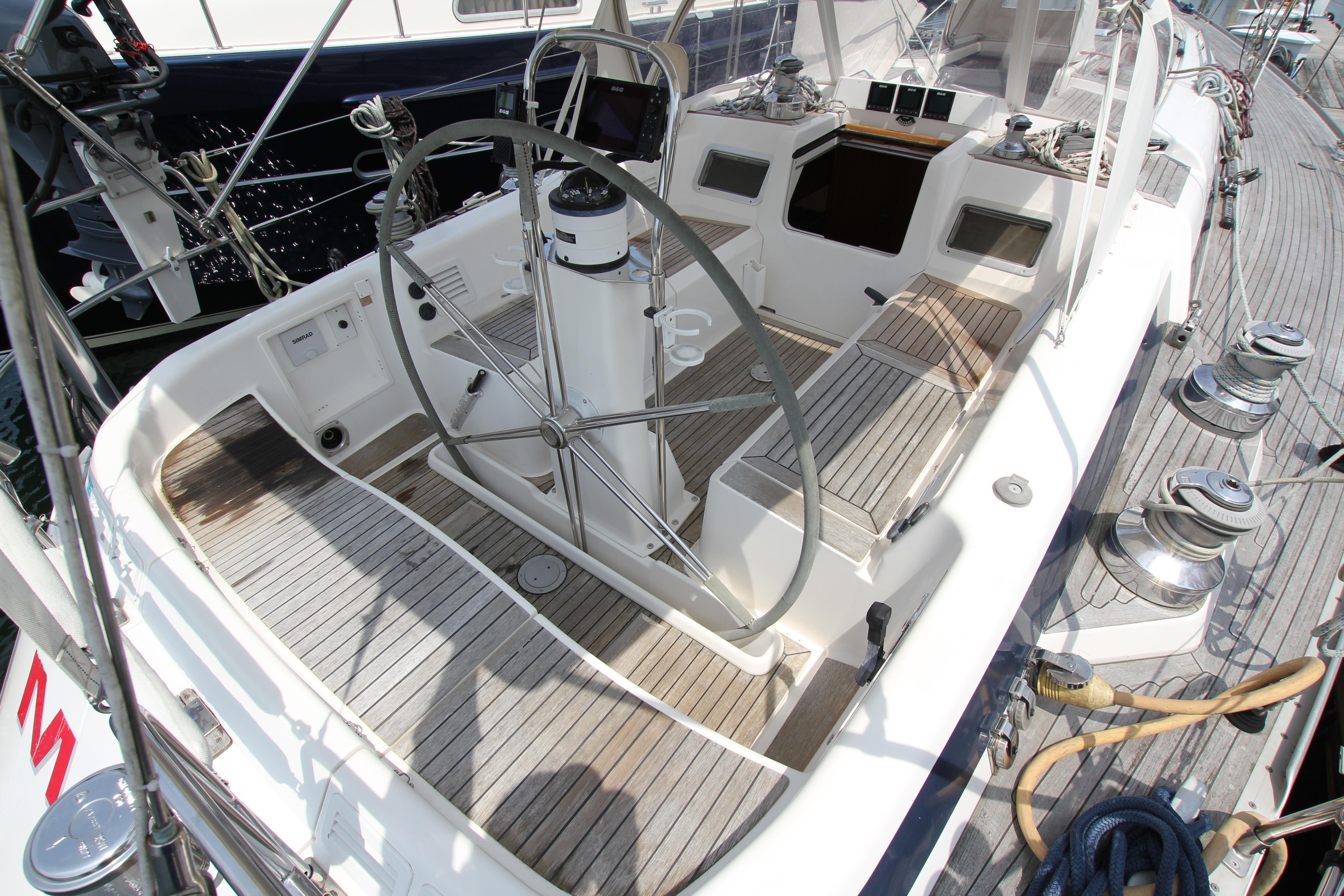 Cockpit of 1997 Nautor Swan 48 sailboat with wooden deck and steering wheel.