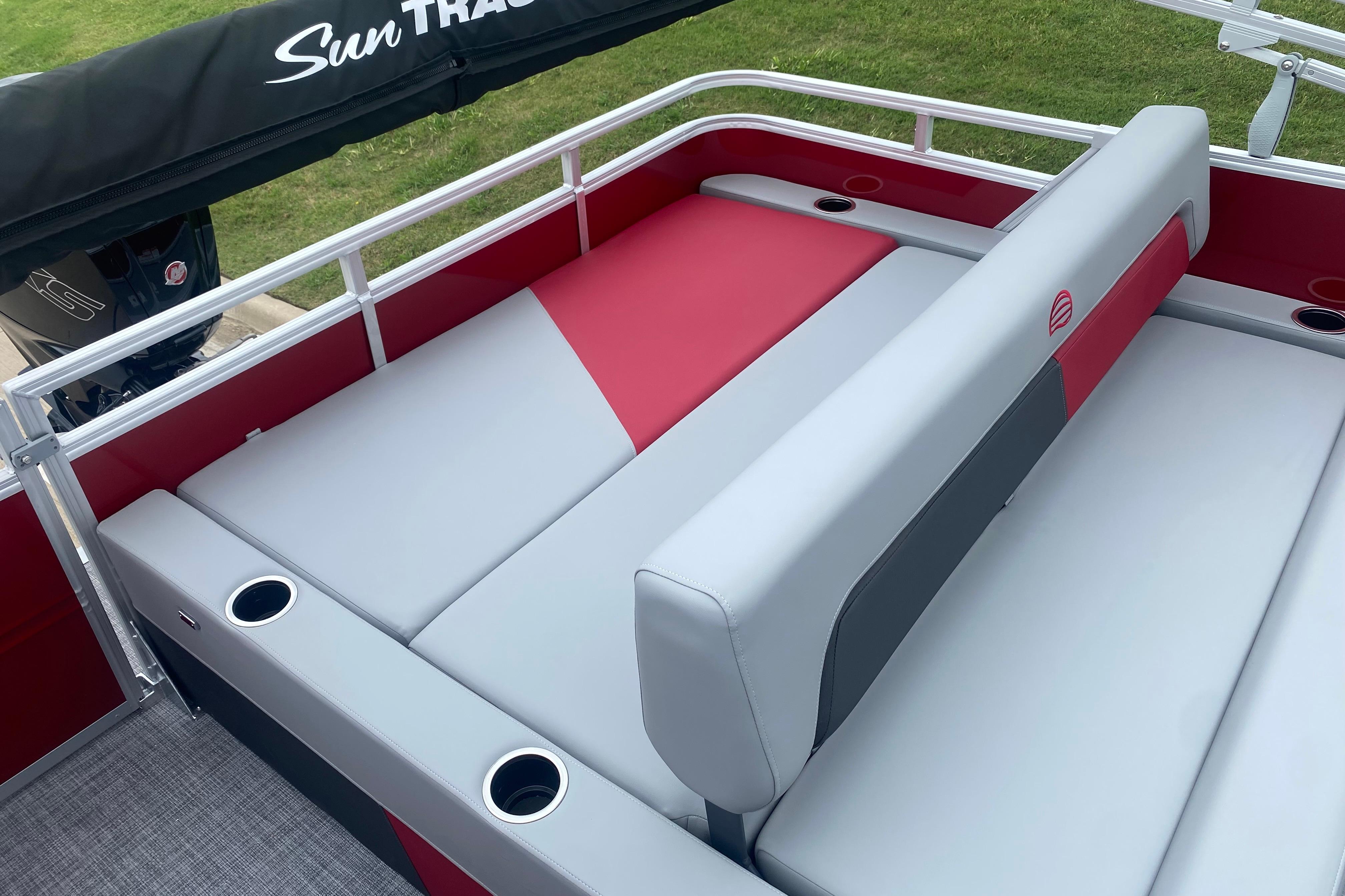 2026 Sun Tracker Party Barge 22 RF DLX with red and gray seating, cup holders, and railing.