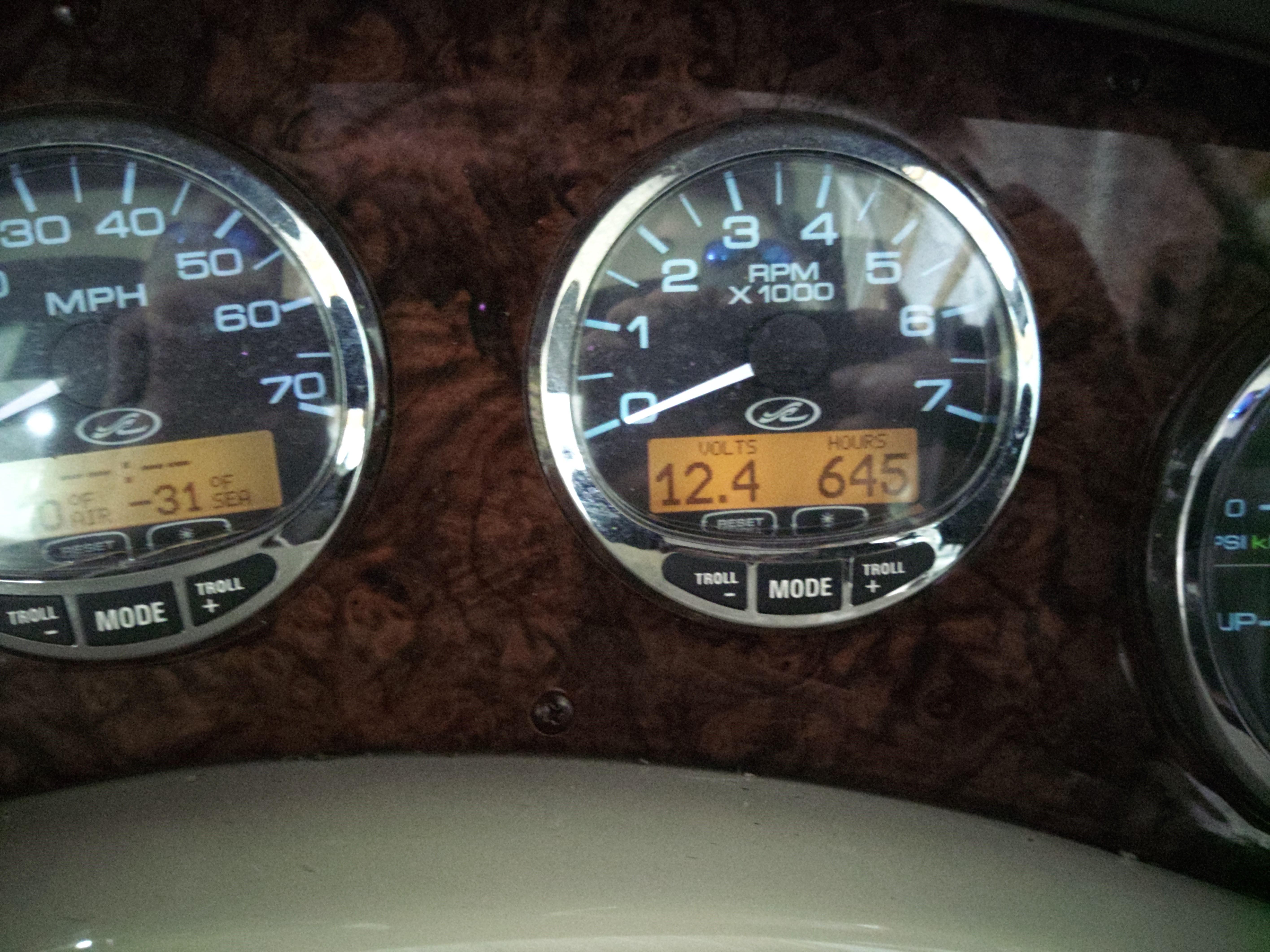 Close-up of 2005 Sea Ray 280 Sundancer dashboard gauges displaying RPM, volts, and engine hours.