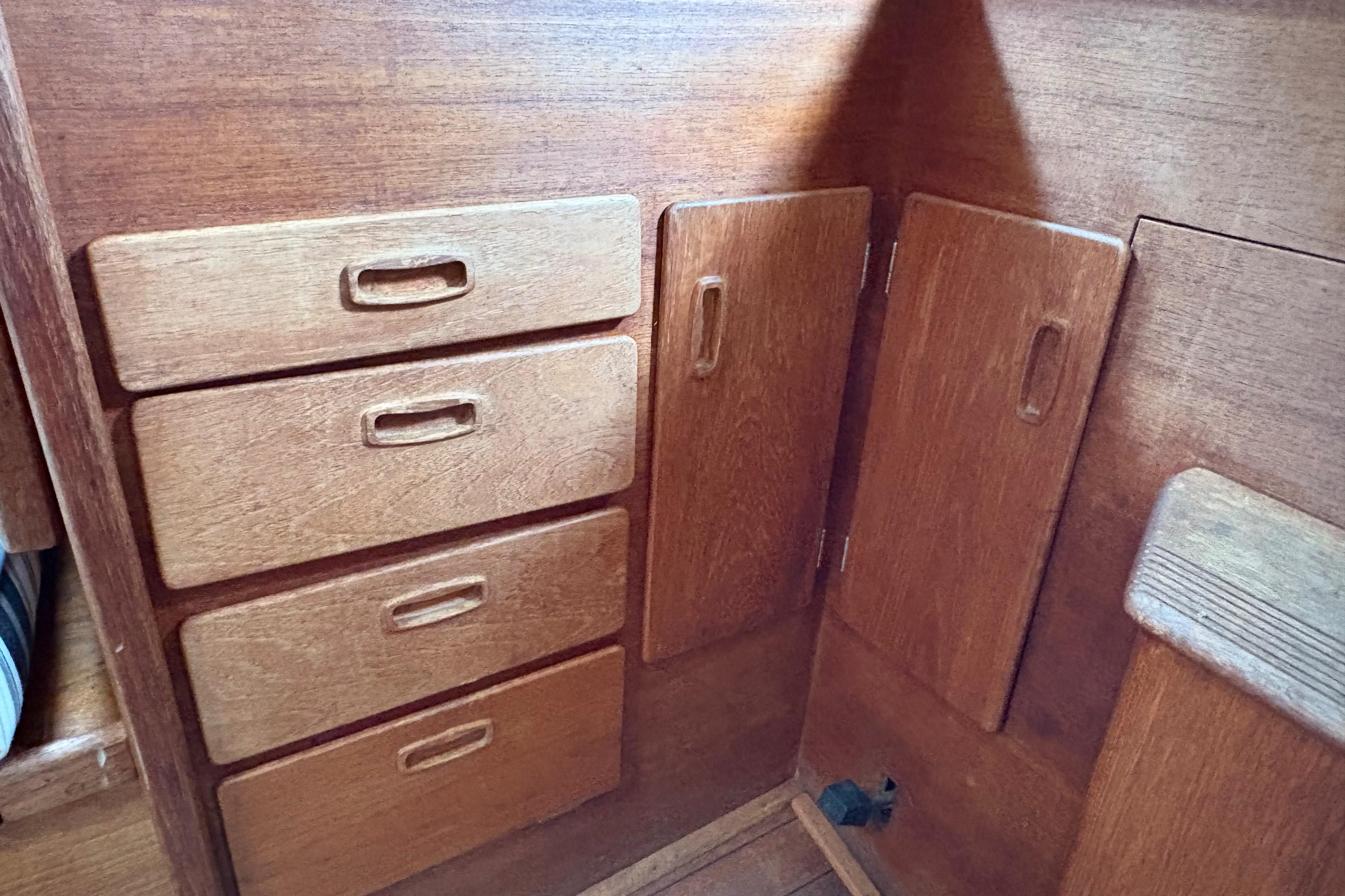 Wooden cabinetry inside a 1981 Sabre 31 sailboat, featuring drawers and cupboards.