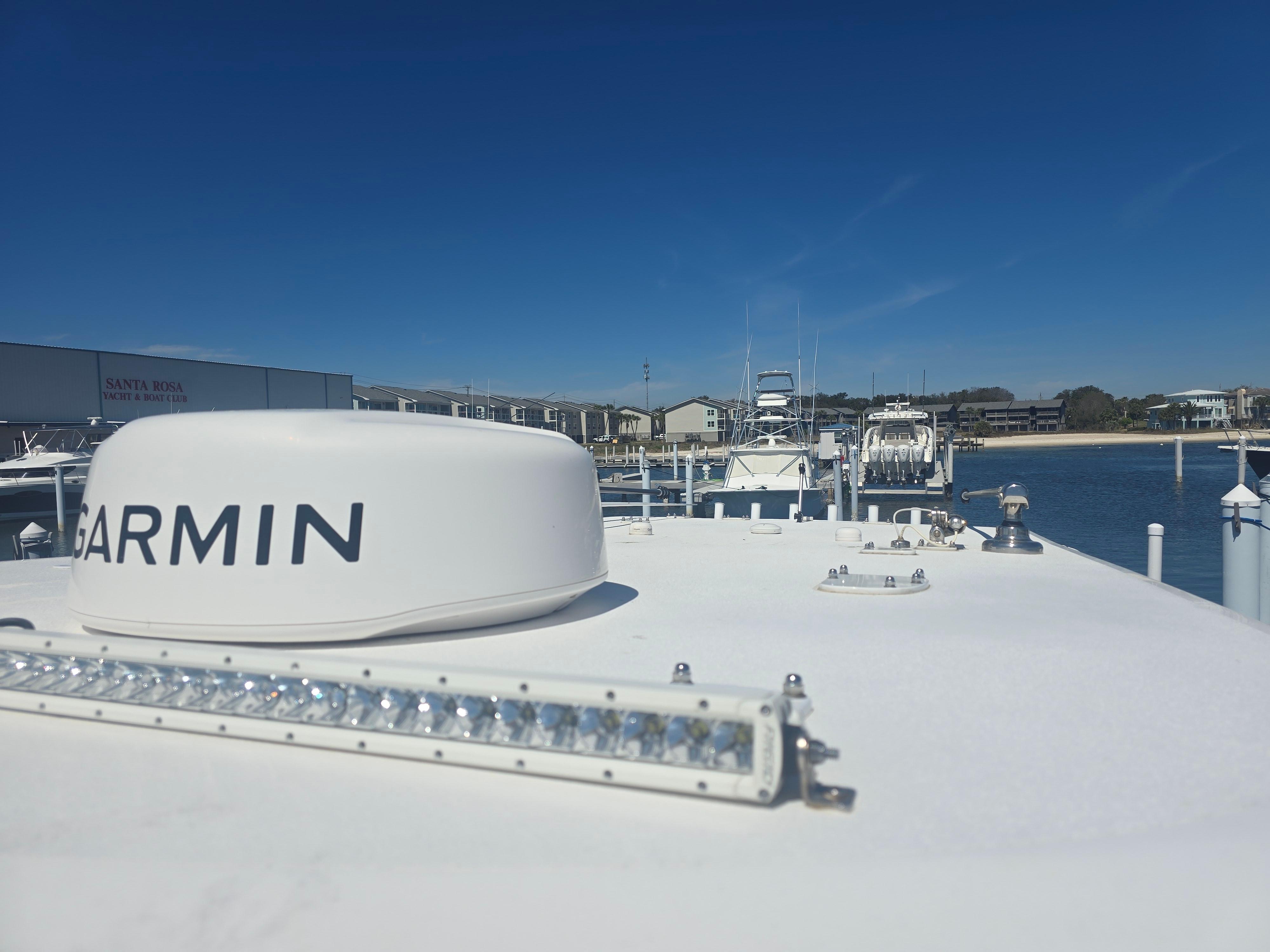 2024 Invincible 43 Open Fisherman boat with Garmin equipment, docked under clear blue sky.
