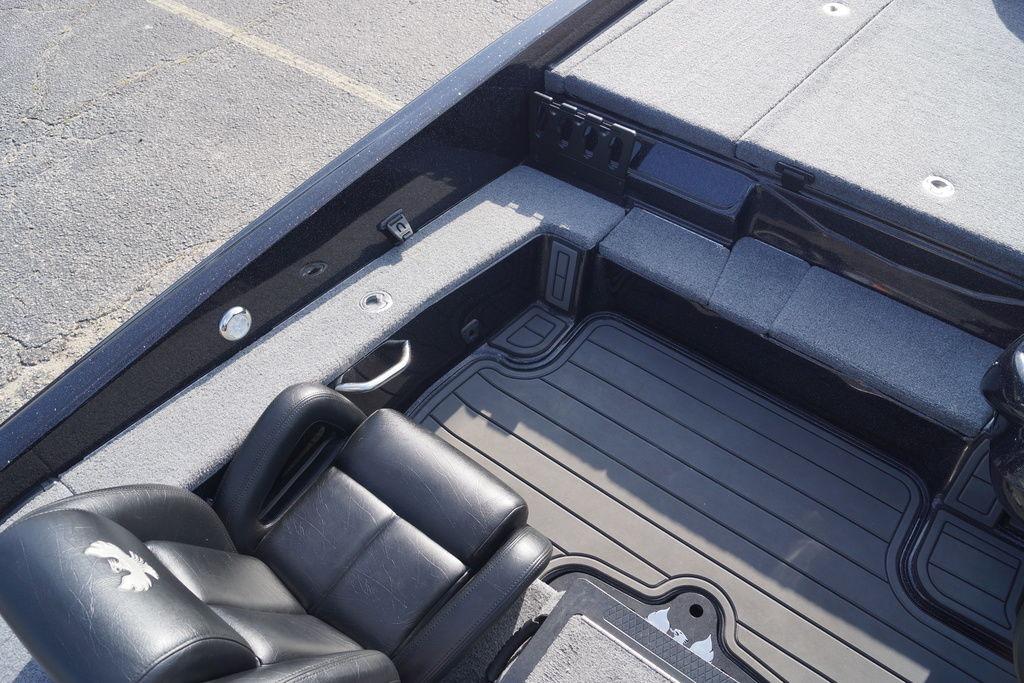 Interior of 2025 Phoenix 921 Elite boat with black leather seating and gray flooring.