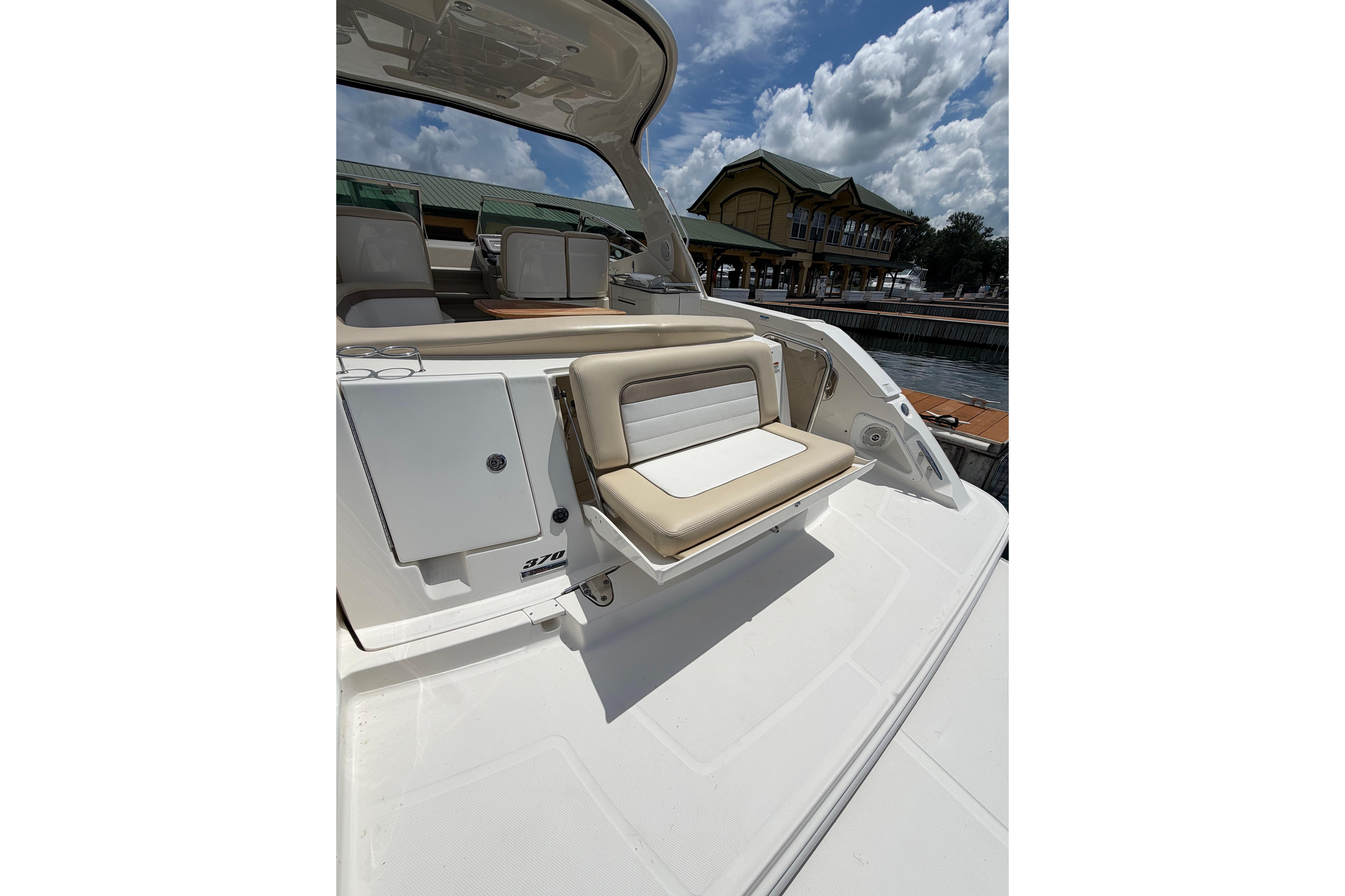 2012 Sea Ray Sundancer 370 boat with seating area, docked under a cloudy sky.