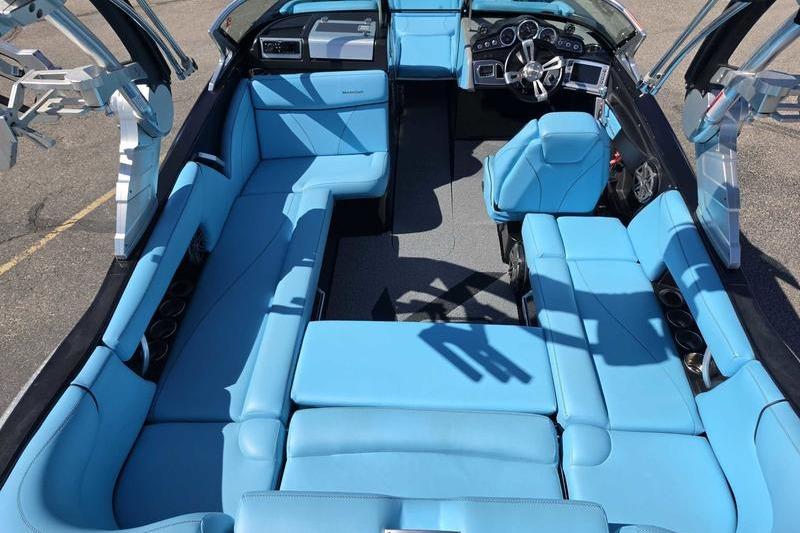 2017 MasterCraft X23 boat interior with blue seating and modern dashboard.