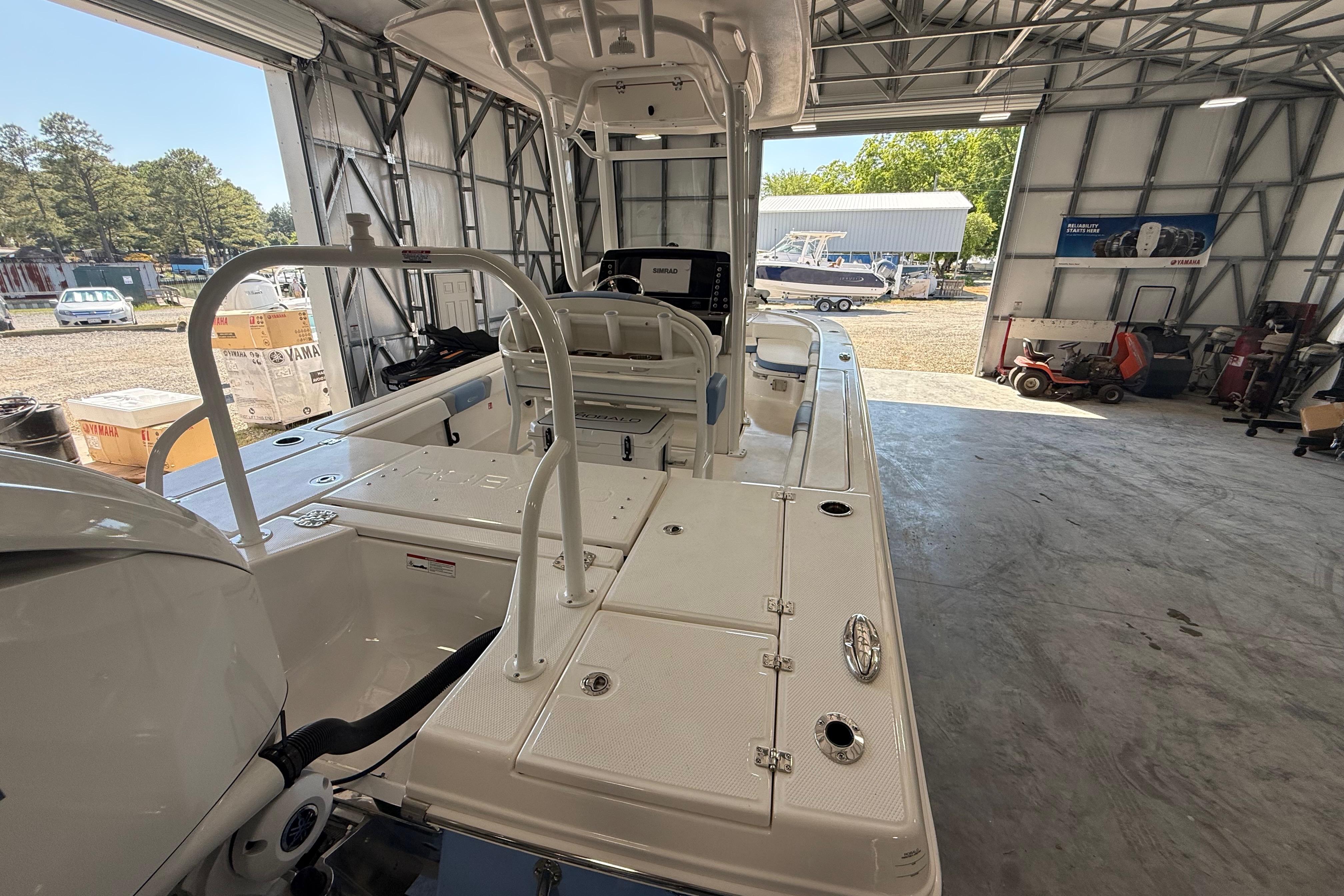 2026 Robalo 246 Cayman boat in a spacious garage, showcasing its sleek design and features.