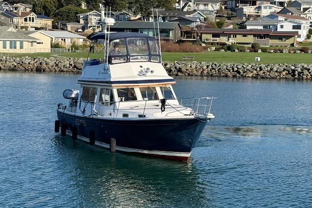 2001 Sabreline Sedan boat cruising in a scenic coastal area.