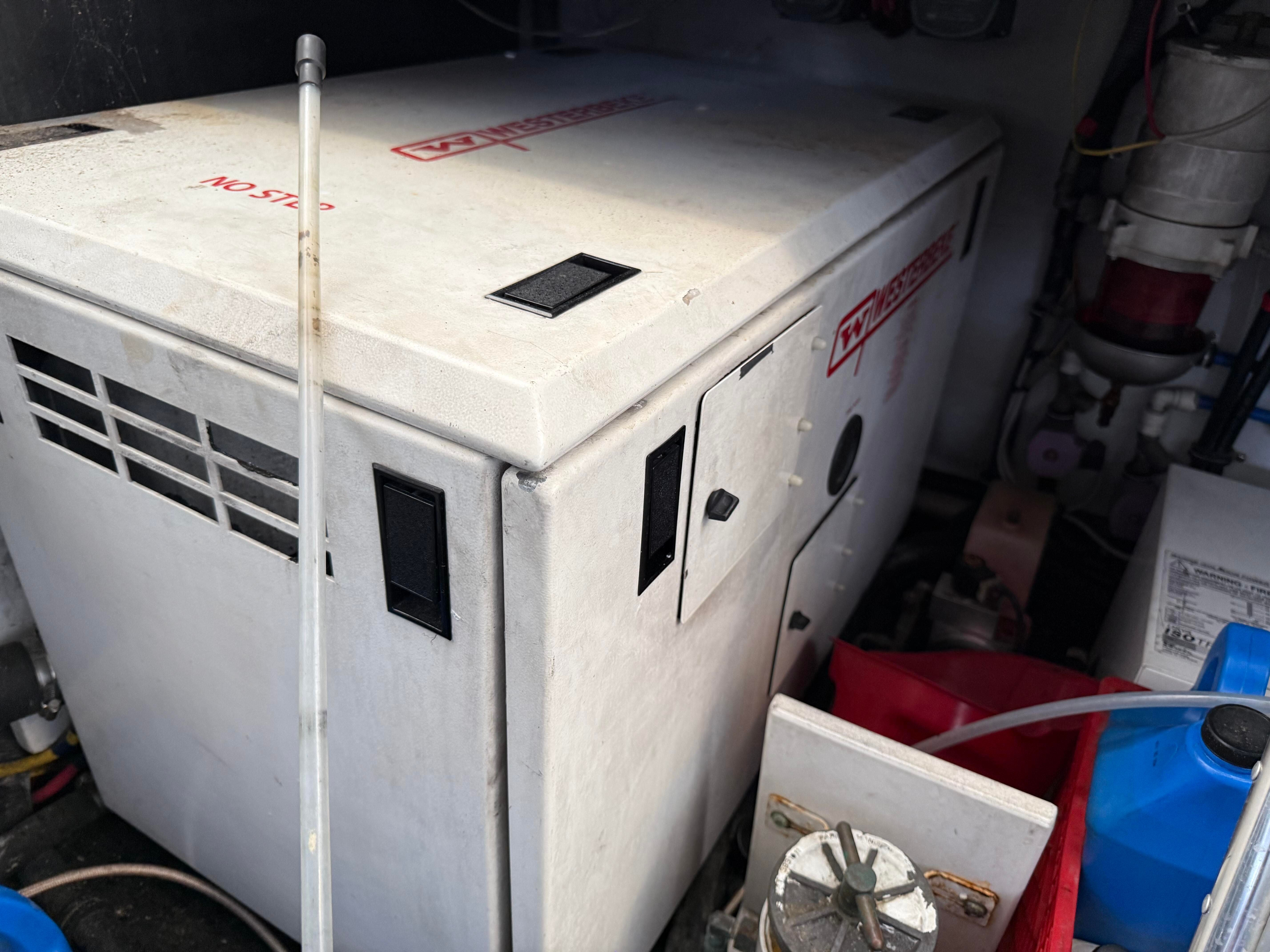 Generator in a boat engine room with various equipment.