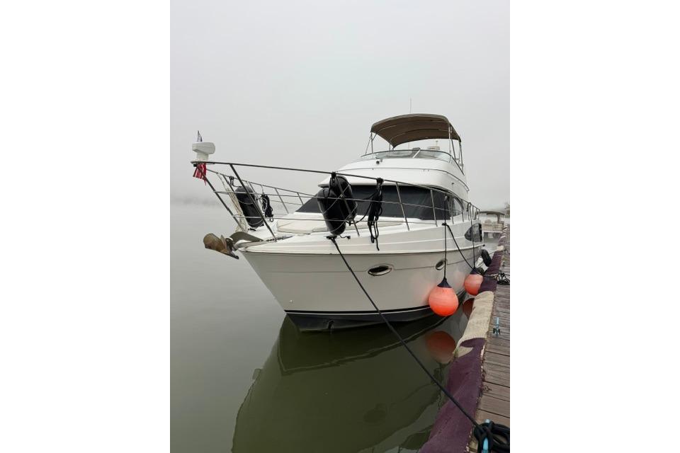 2003 Carver 36 Super Sport yacht docked with orange buoys.