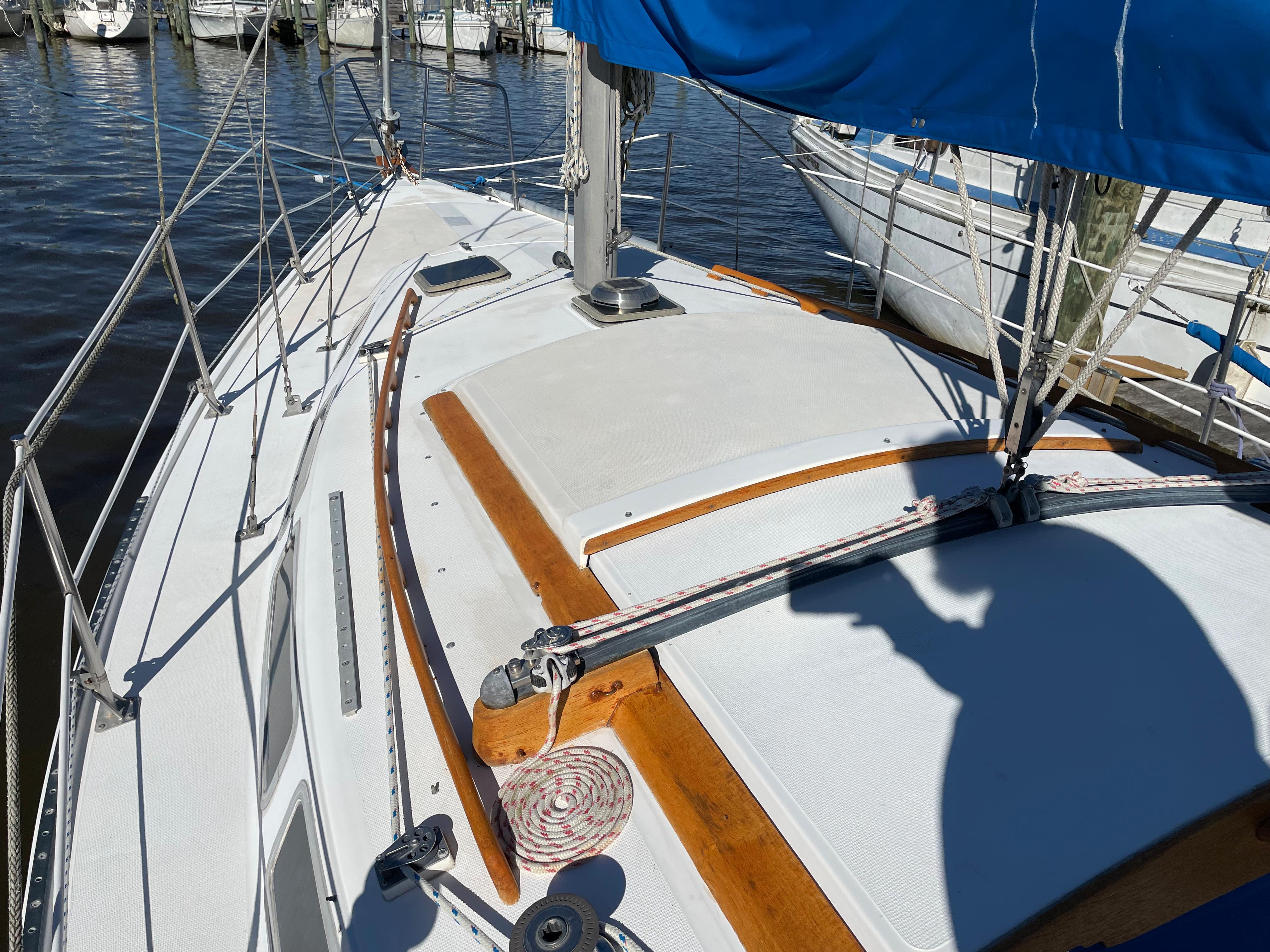 1982 Catalina 30 sailboat deck with blue sail cover, docked in marina.