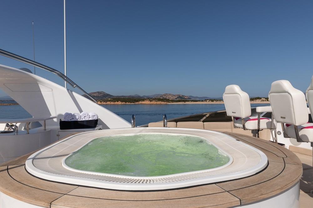 Luxurious jacuzzi on 2008 Benetti Classic 120 yacht with ocean view and seating area.