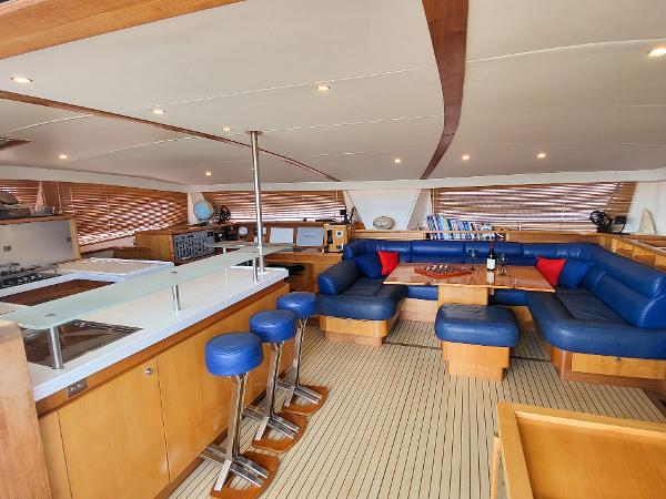 Luxurious interior of a 2009 Catana 65 yacht with blue seating and modern amenities.