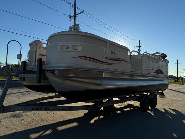 2005 Starcraft 22 Sport pontoon boat on trailer, parked outdoors.
