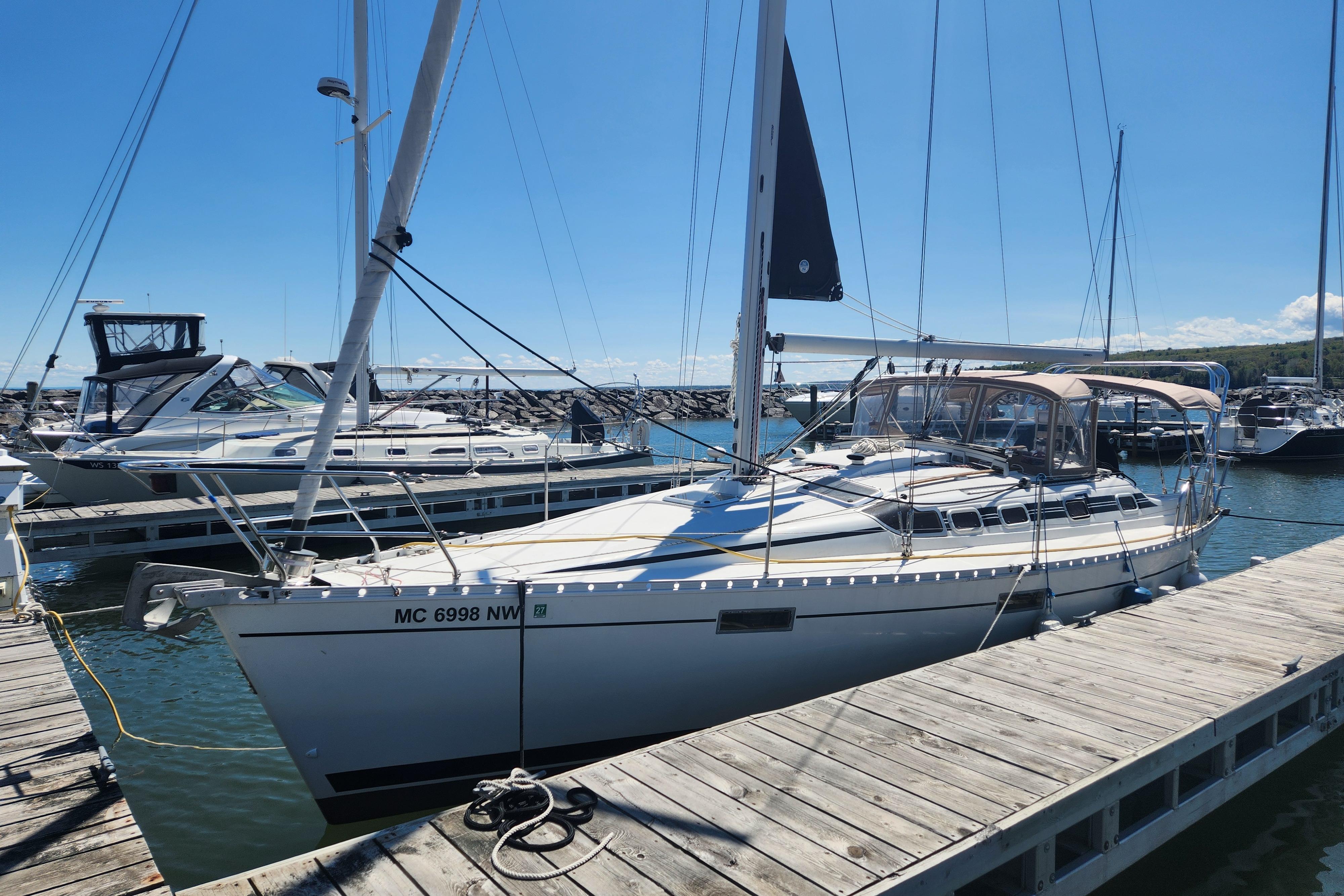1991 Beneteau Oceanis 370 sailboat docked at a marina under clear blue skies.