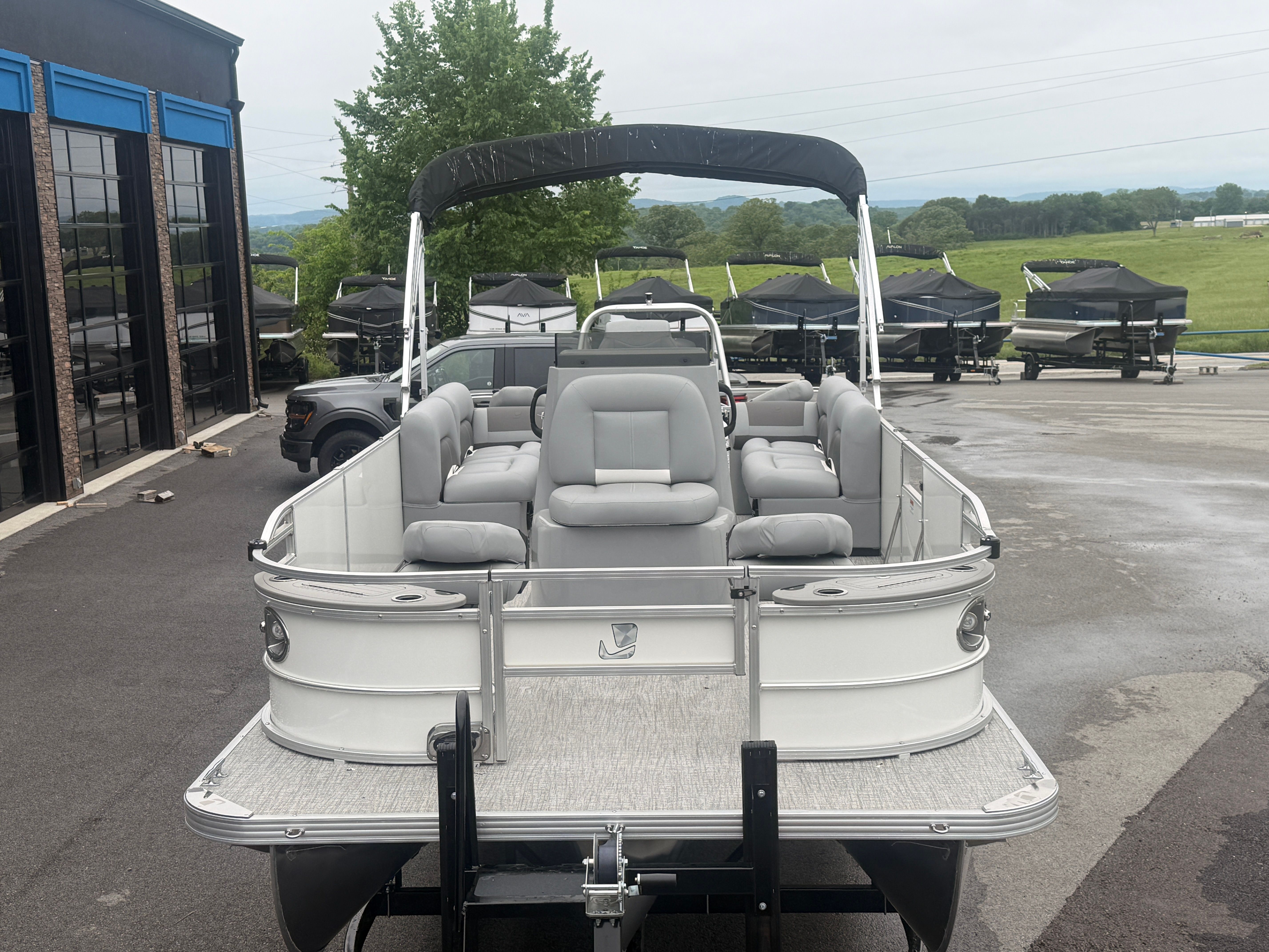 2026 Landau Alure 23CC Fish pontoon boat on parking lot.
