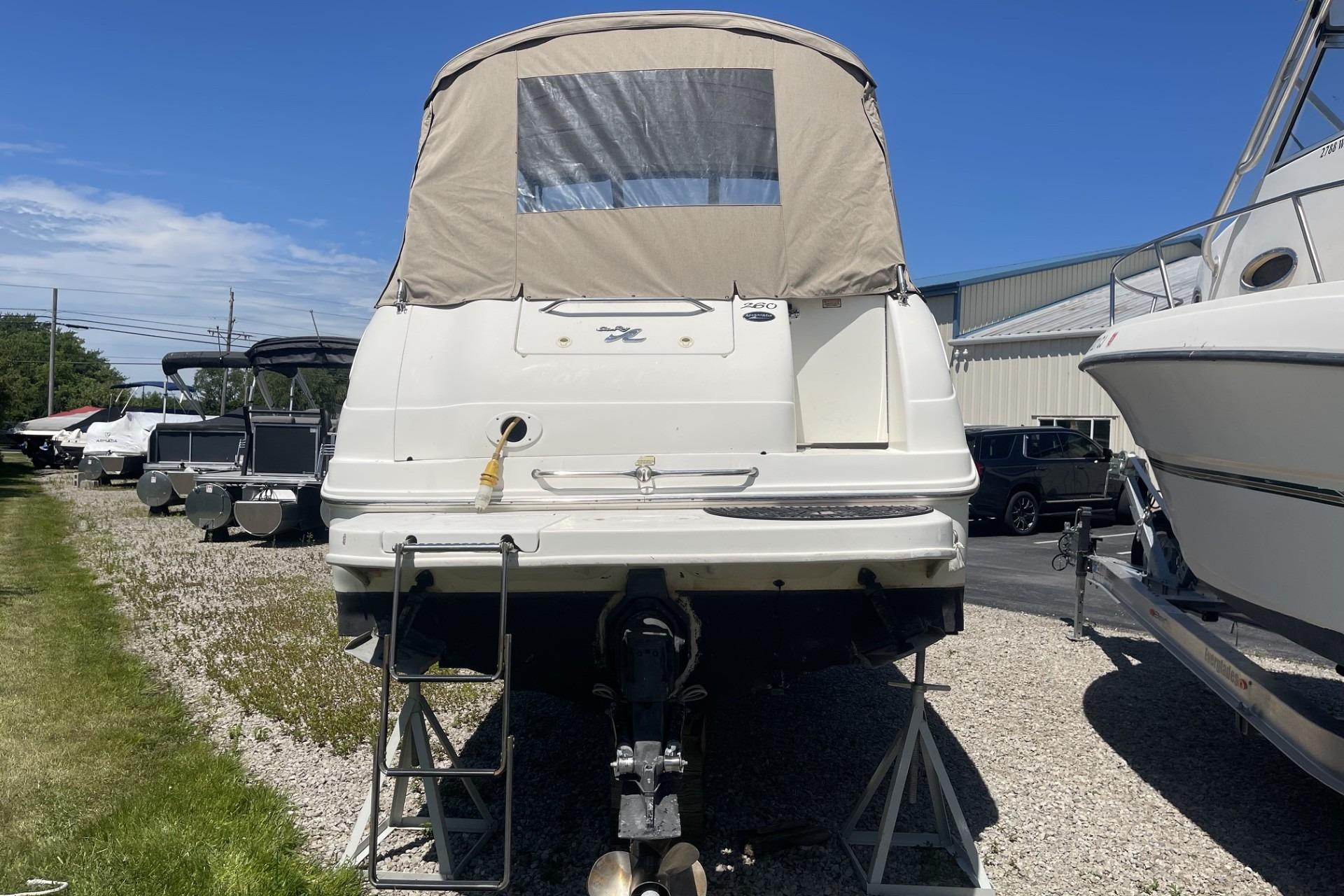 2000 Sea Ray Sundancer 260 boat on stands, rear view, in a marina setting.