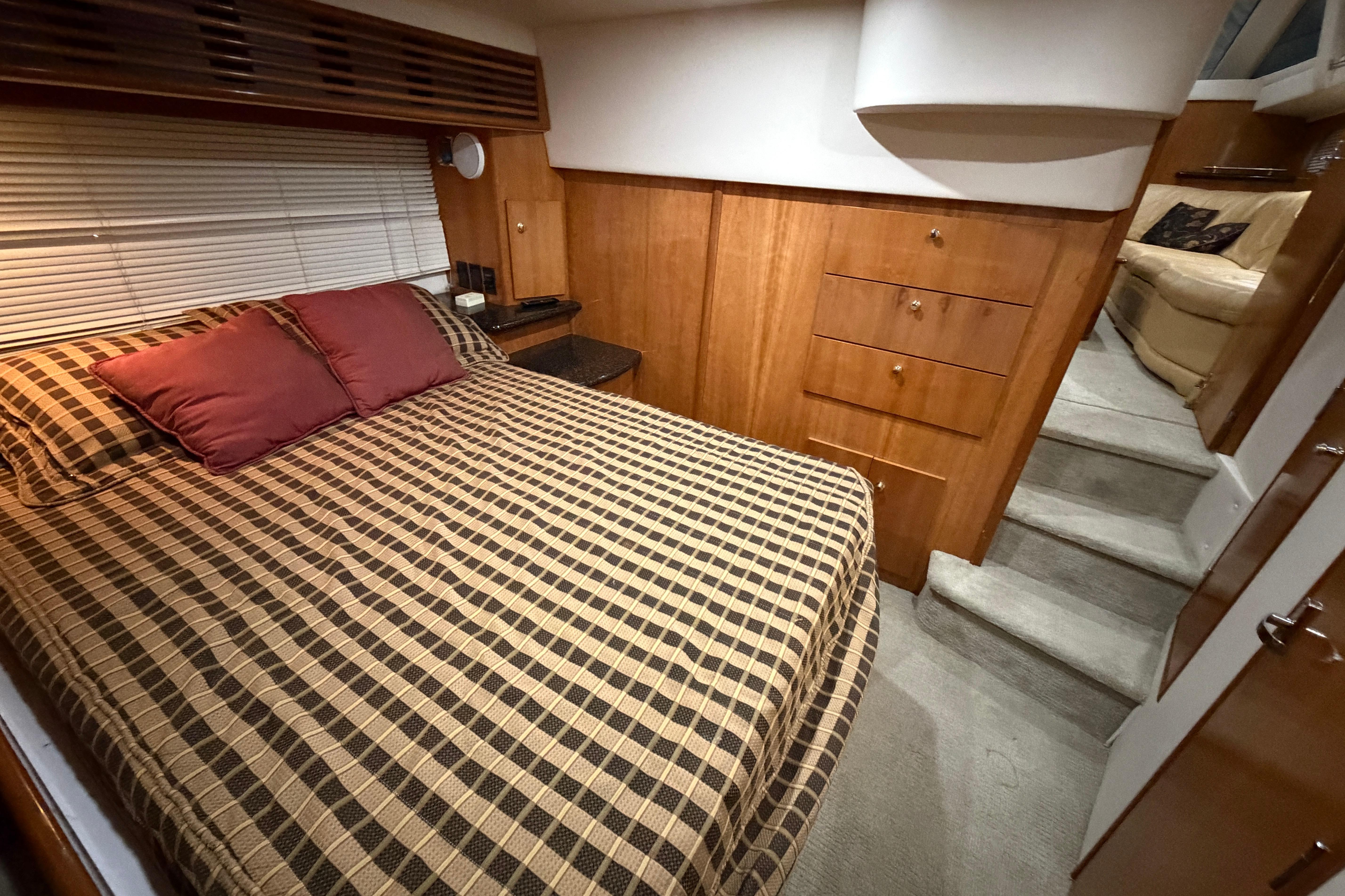 Interior of 2001 Carver 444 Cockpit Motor Yacht with cozy bedroom and wooden cabinetry.