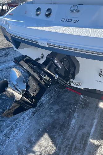 2024 Tahoe 210 Si boat stern with outboard motor on a snowy surface.