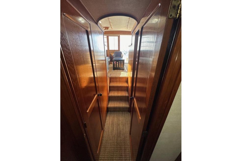 Interior view of 1985 Egg Harbor 33 Sedan yacht with wooden finishes and carpeted steps.