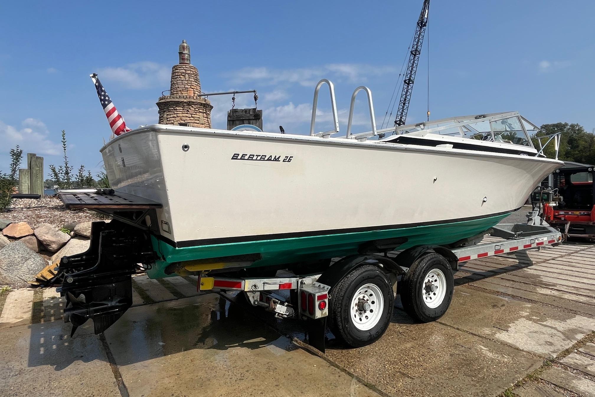 1975 Bertram 26 Moppie boat on trailer, displayed outdoors with American flag.