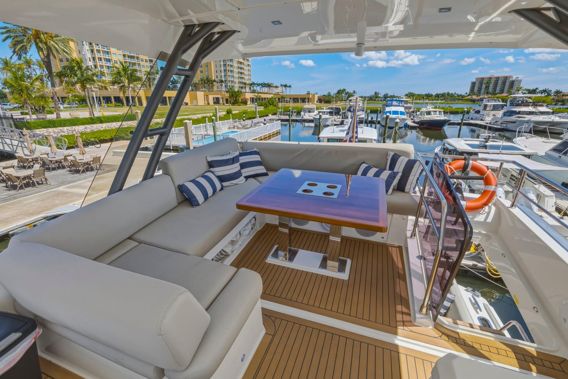 Luxurious 2022 Prestige 520 yacht interior with elegant seating and marina view.