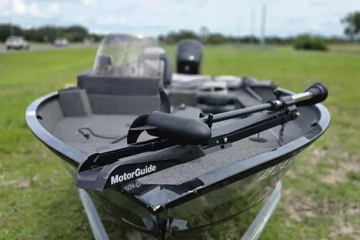 2021 Lowe Fishing Machine 1775SC boat with MotorGuide trolling motor on grassy field.