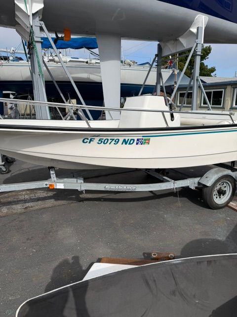A white 1992 Boston Whaler 13' jet boat on a trailer.
