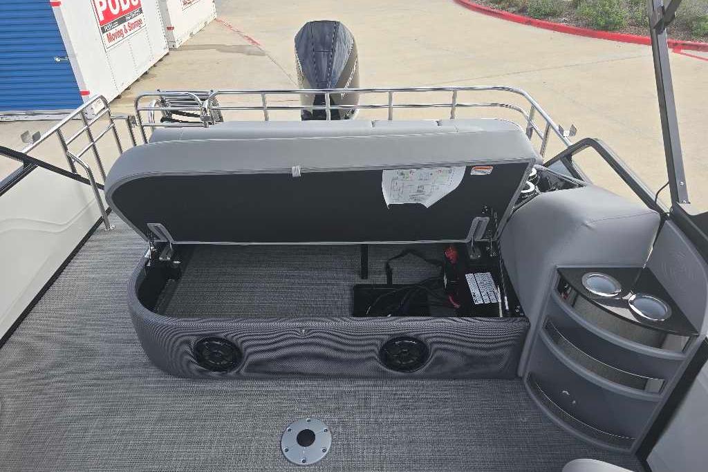 2025 Regency 250 LE3 Sport boat interior with open storage compartment and cup holders.