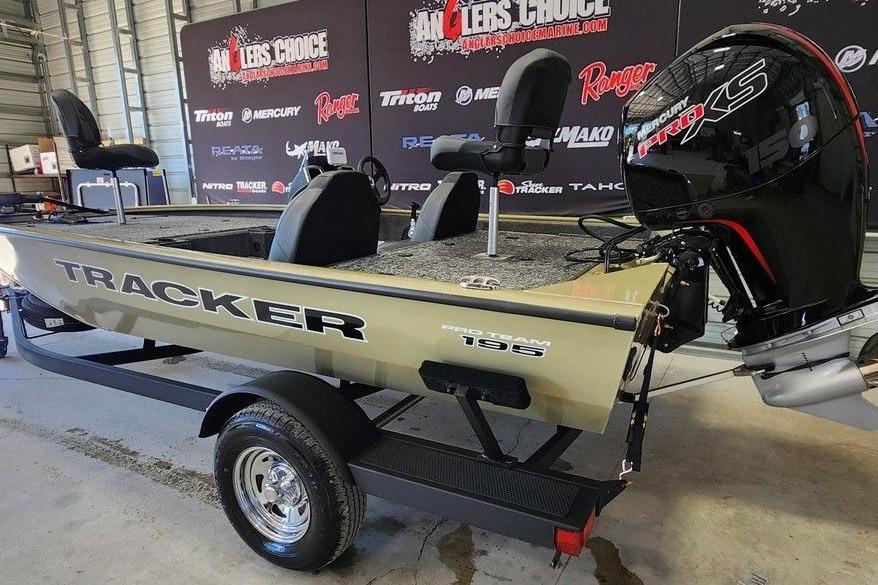 2026 Tracker Pro Team 195 boat on trailer, displayed indoors with promotional banners.