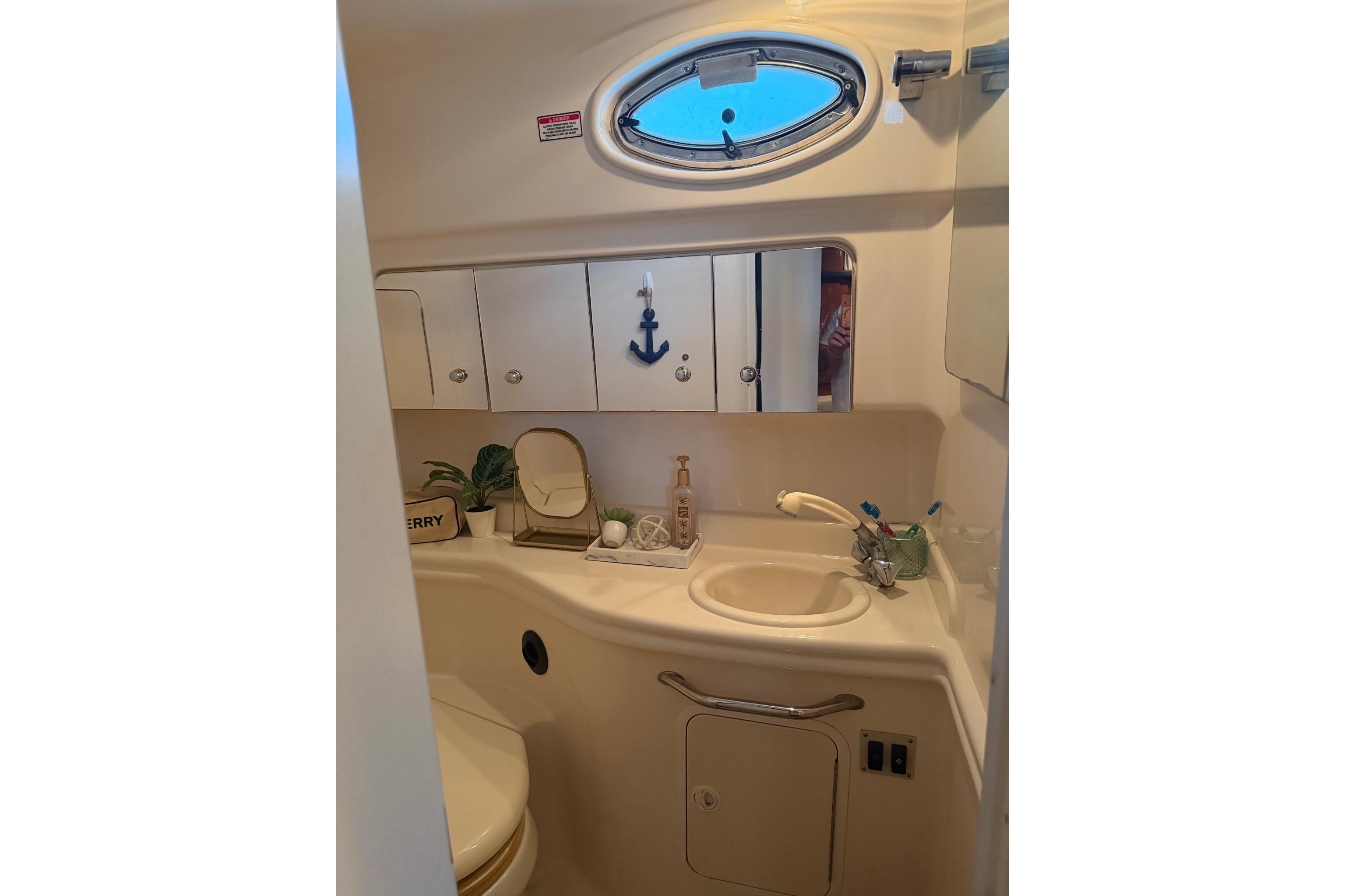 2002 Sea Ray Sundancer 320 bathroom with sink, mirror, and nautical decor.