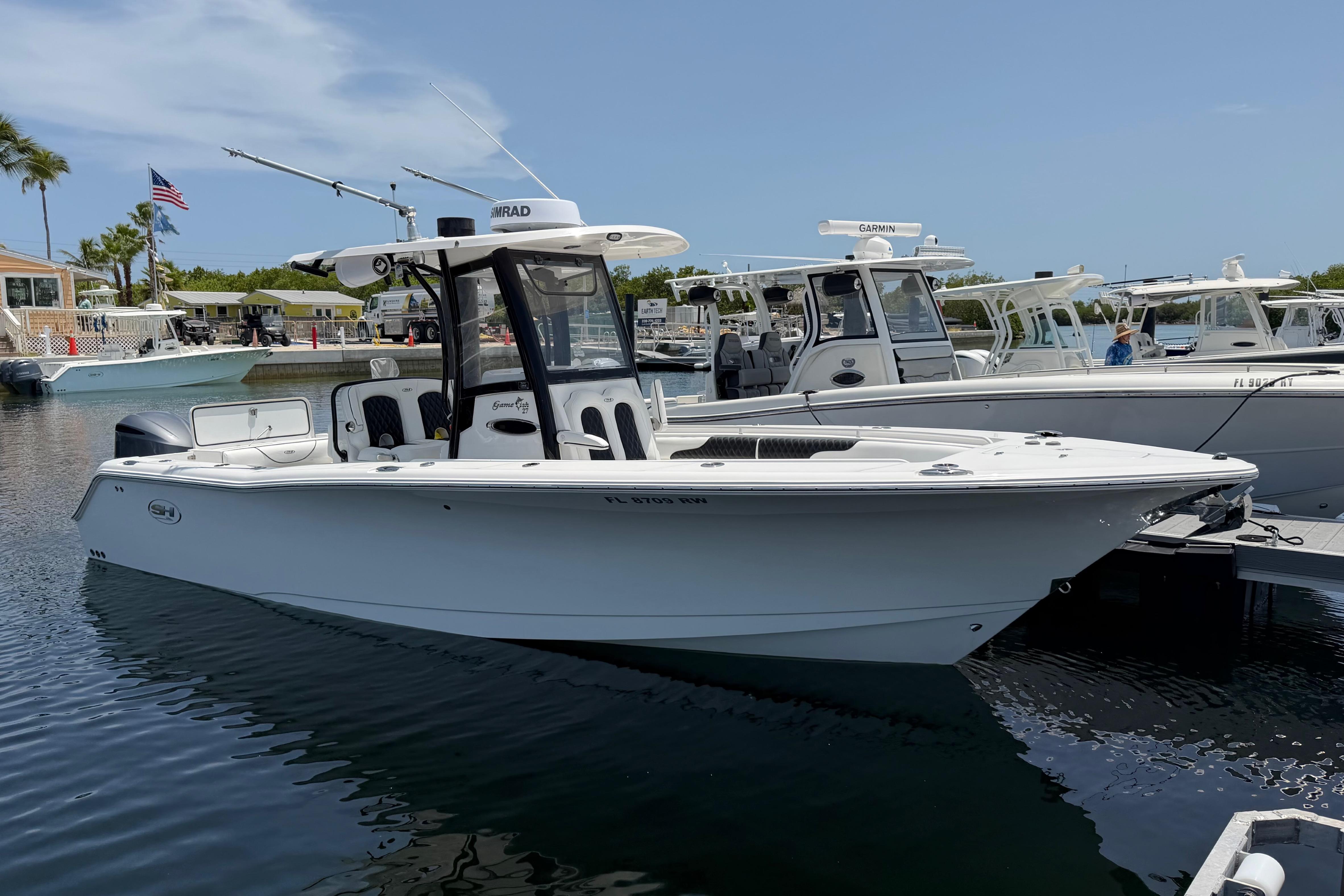 2019 Sea Hunt Gamefish 27 Coffin Box boat docked in marina, clear sky background.
