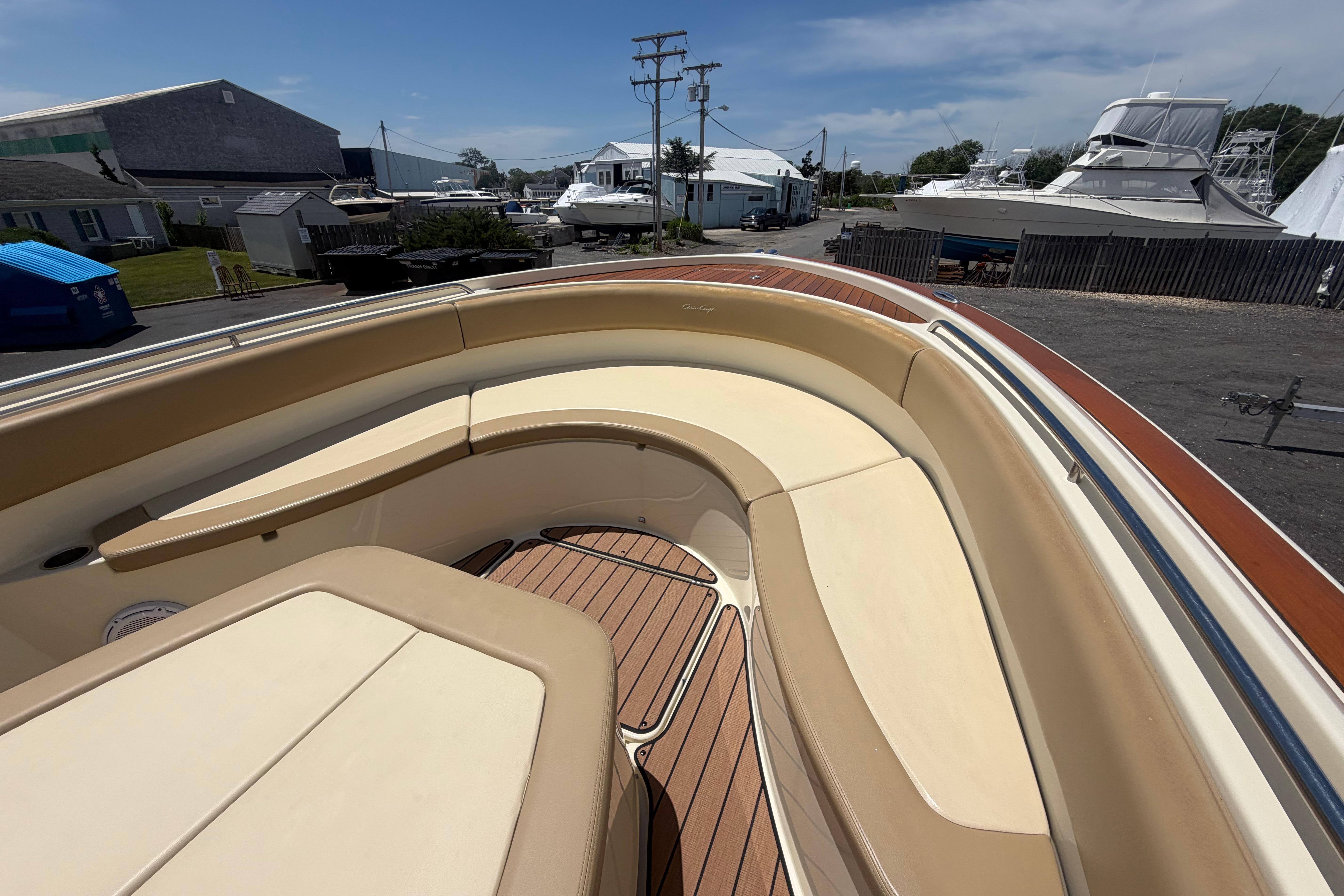 2017 Chris-Craft Catalina 34 boat with beige seating and wooden deck in a marina.