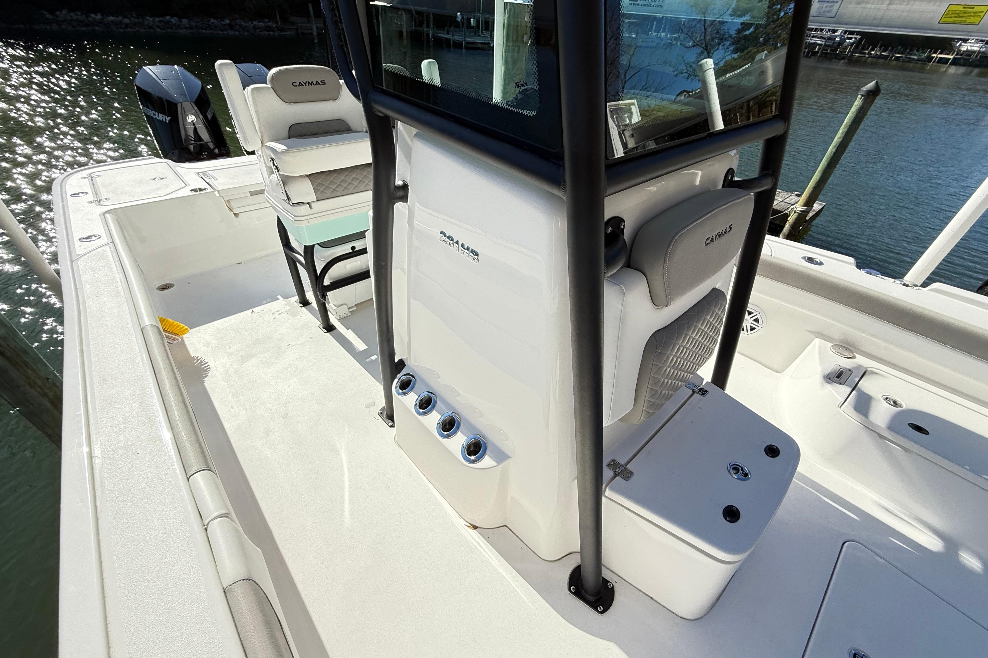 2023 Caymas 281 HB boat interior with seating and storage, docked by the water.