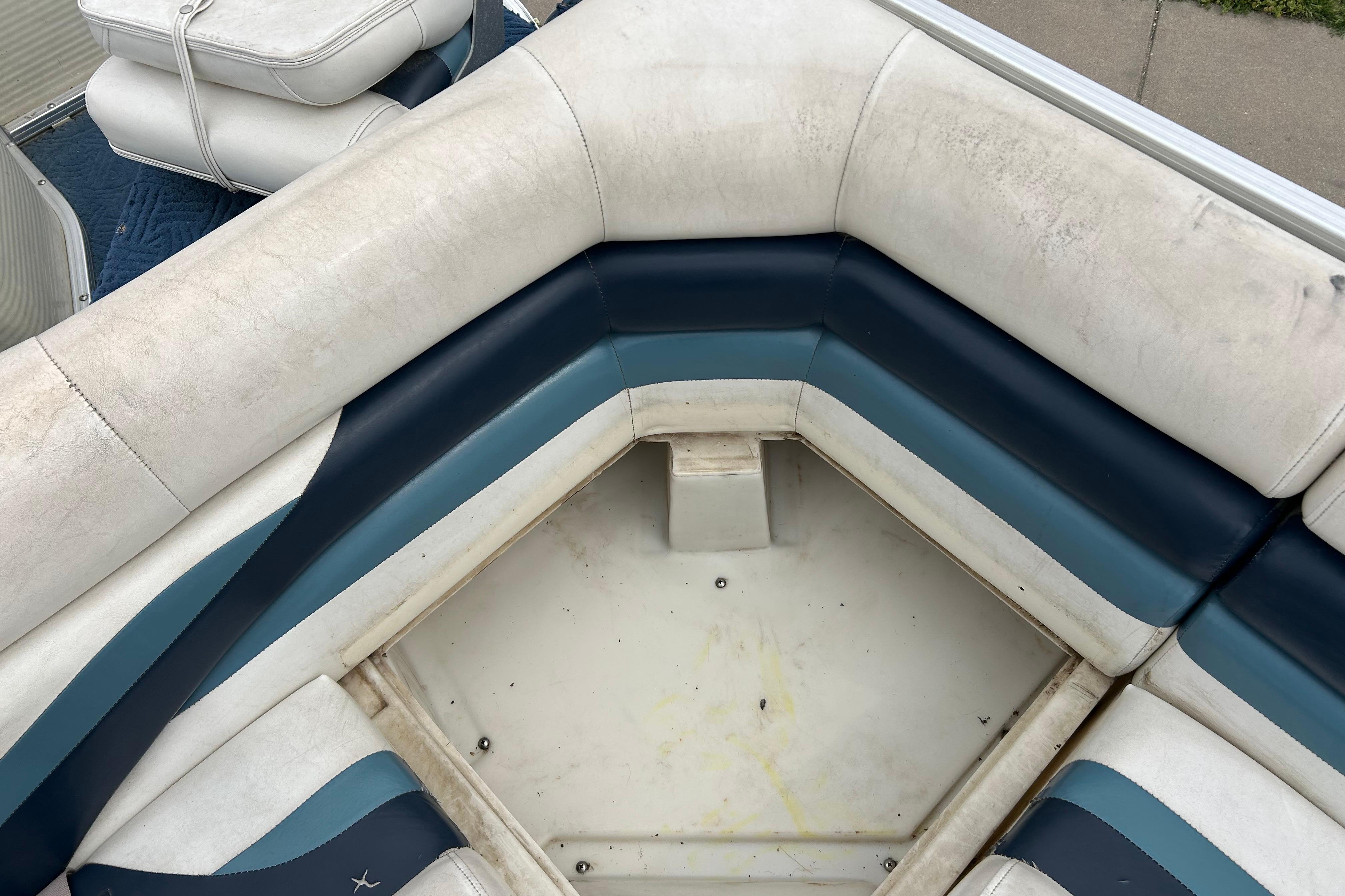 Interior seating of a 2002 Lowe Trinidad 200 boat, featuring white and blue upholstery.