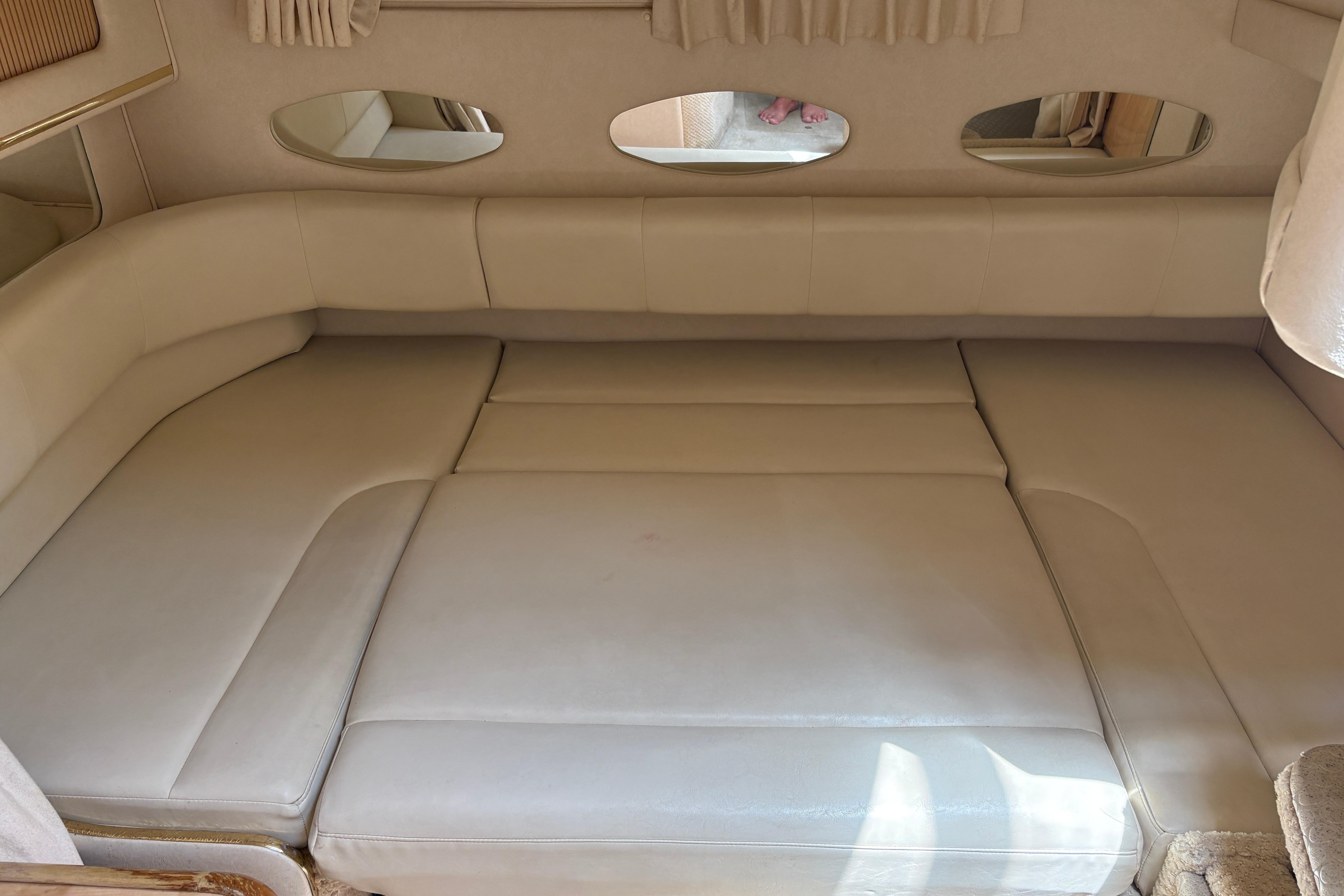Interior cabin seating of 2001 Sea Ray Sundancer 310 boat, featuring beige upholstery.