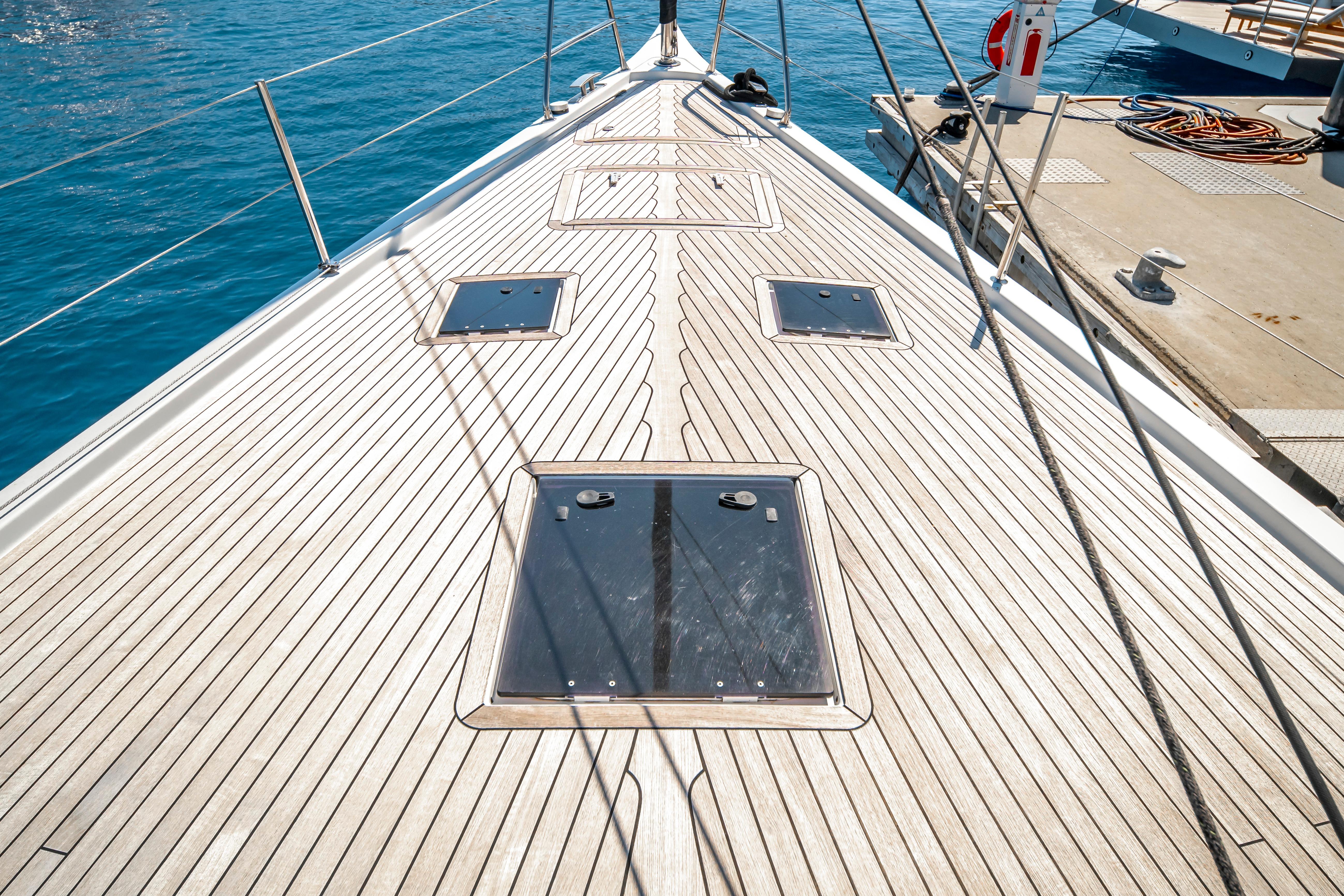 Deck of 2016 Grand Soleil 58 yacht with sleek wooden finish and ocean backdrop.