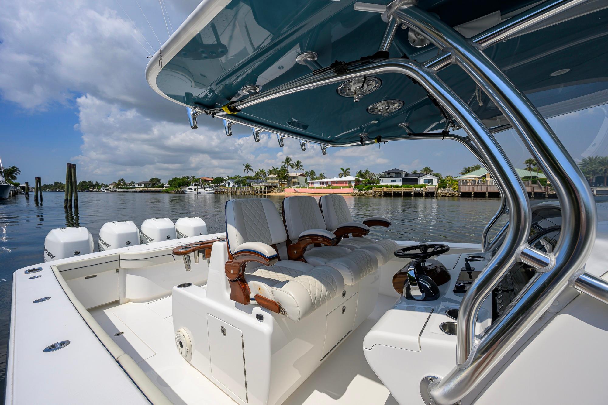 2020 Valhalla Boatworks V-41 luxury boat interior with helm and seating, docked by waterfront homes.