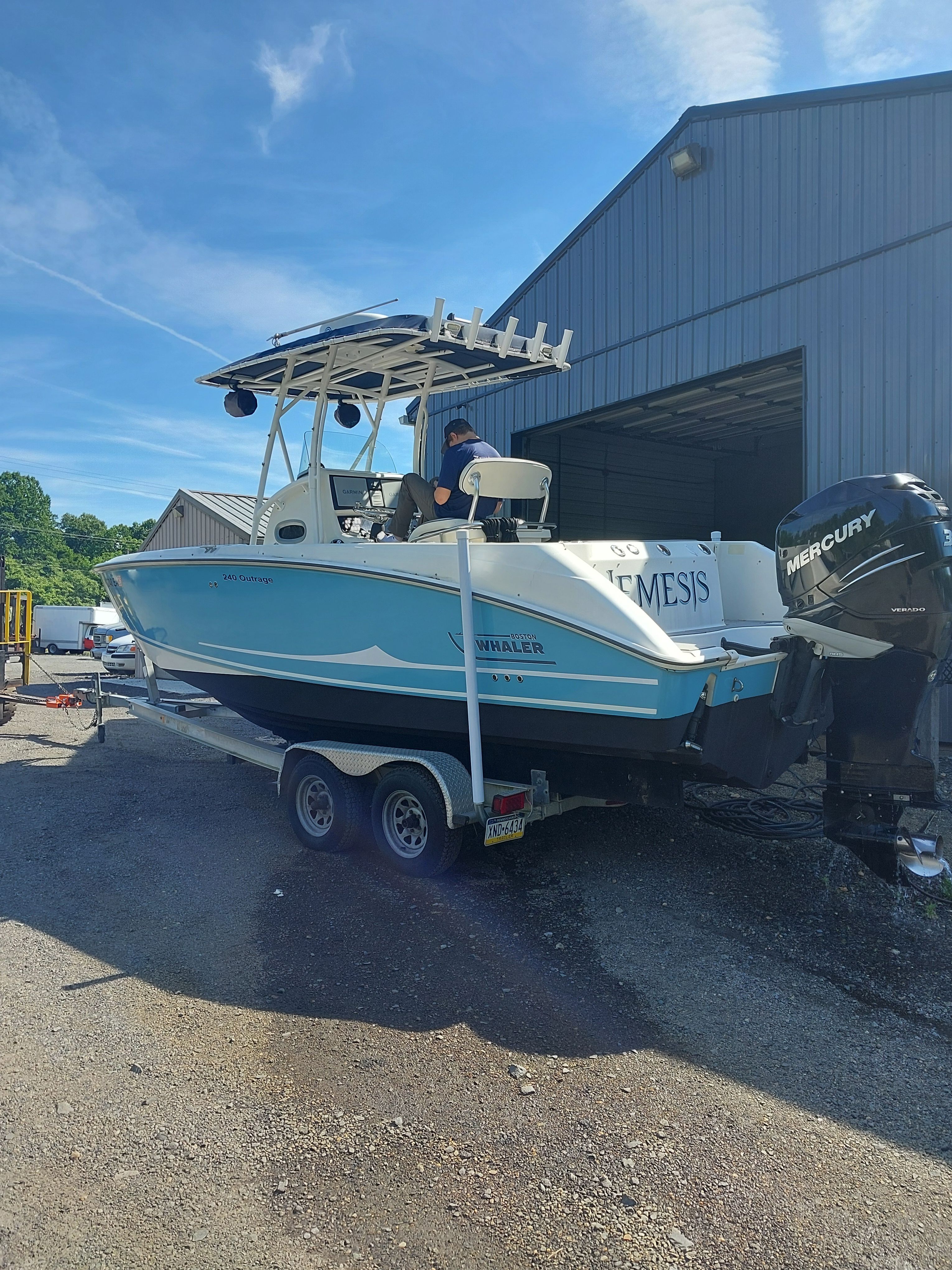 2005 Boston Whaler 240 Outrage on a trailer outside a warehouse.