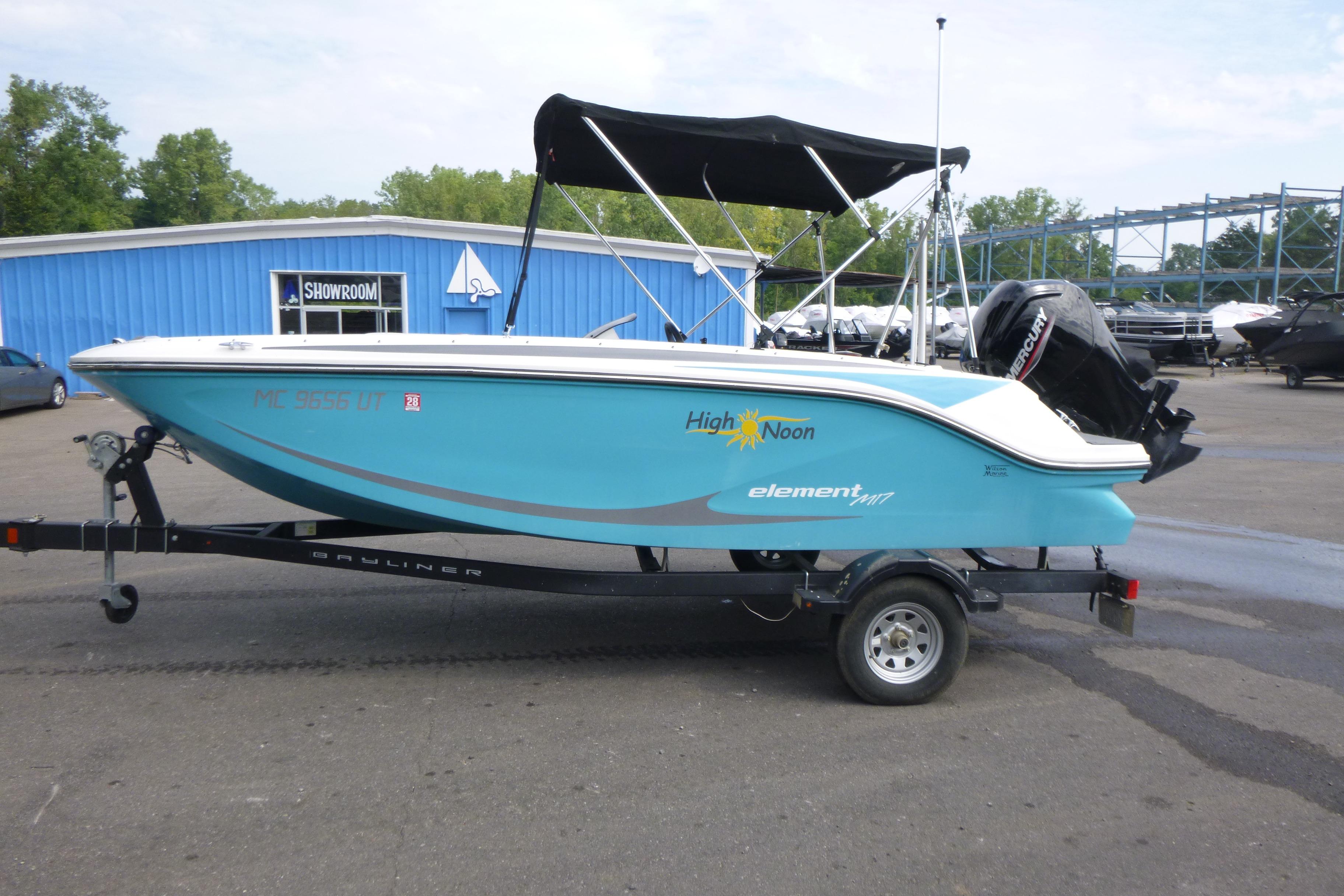 2022 Bayliner Element M17 boat on trailer, blue exterior, parked near showroom.