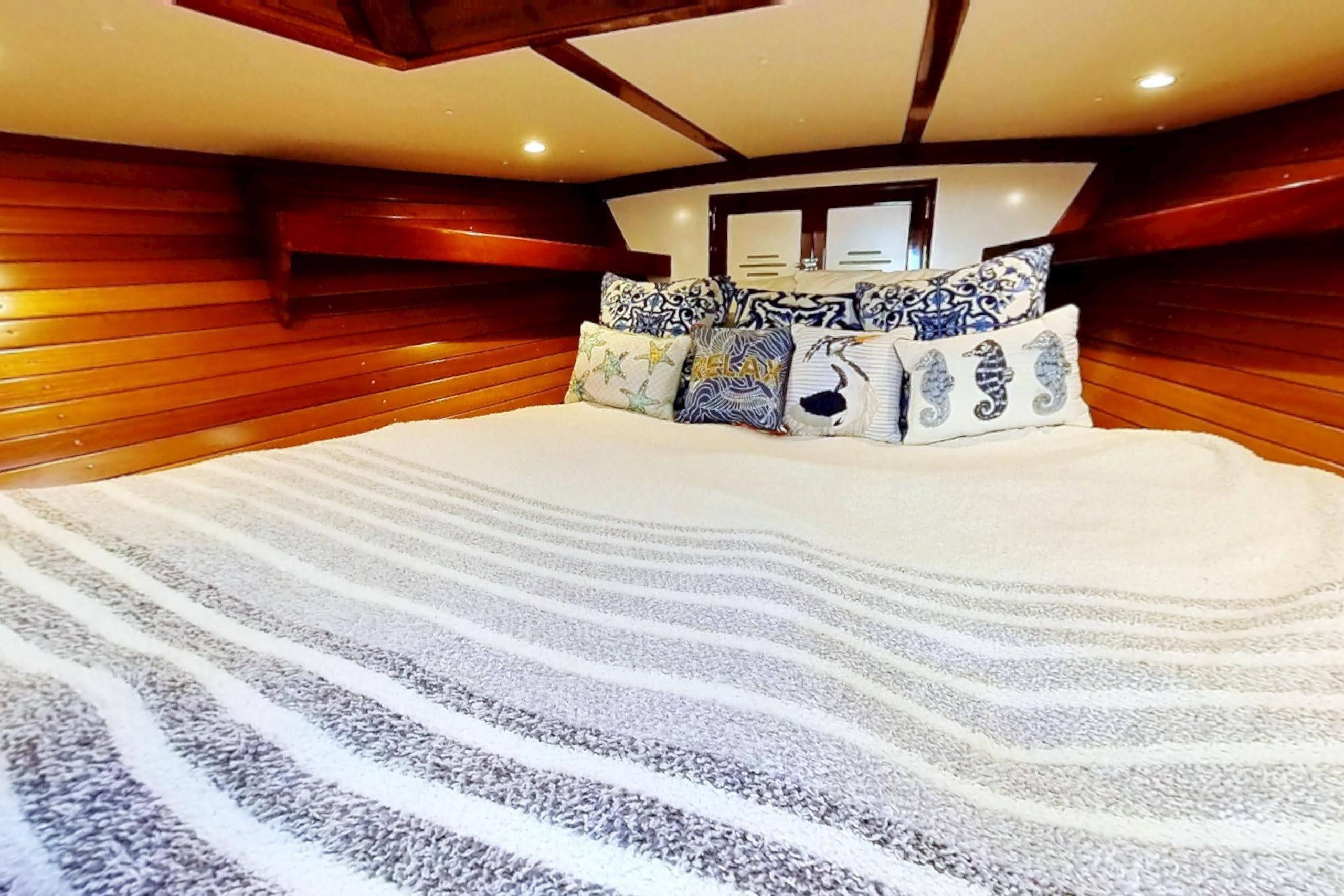 Cozy cabin interior of 1970 Hinckley Bermuda 40 with nautical-themed pillows.