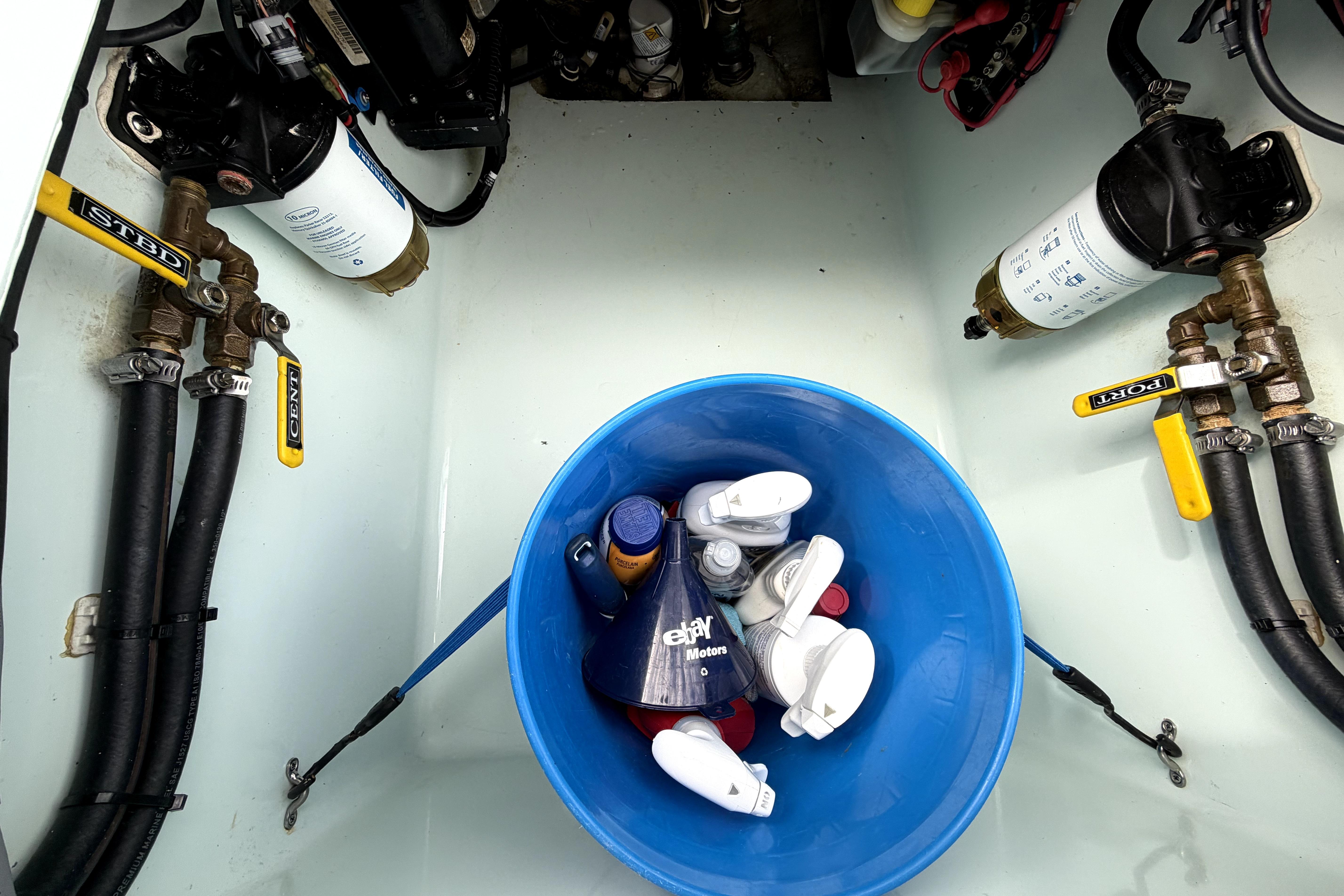 Engine compartment of 2019 Contender 30 ST with filters and maintenance supplies.