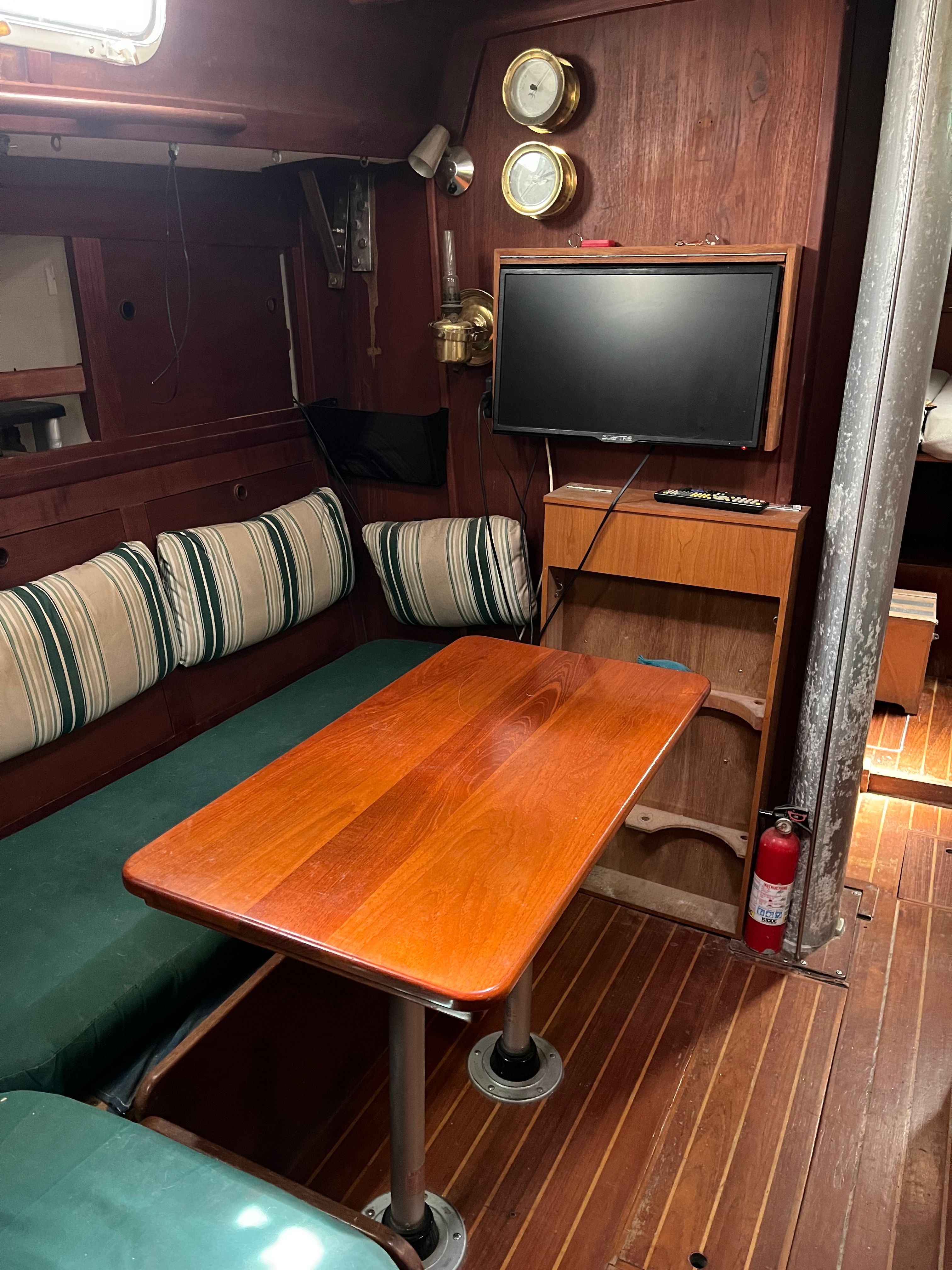 Interior of a 1981 Tartan Sloop with a wooden table and seating area.