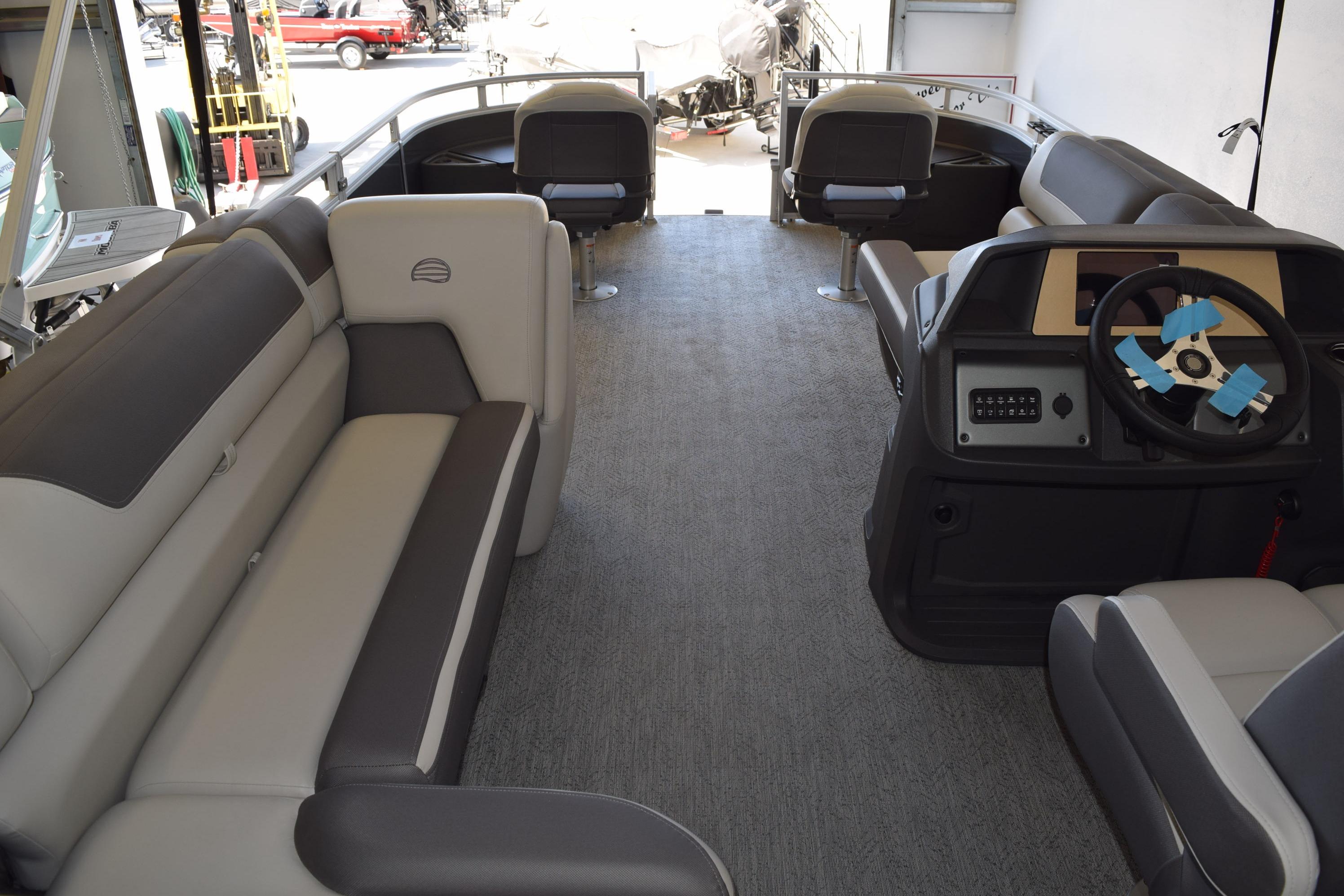 2026 Sun Tracker Fishin' Barge 22 DLX interior with spacious seating and modern helm.