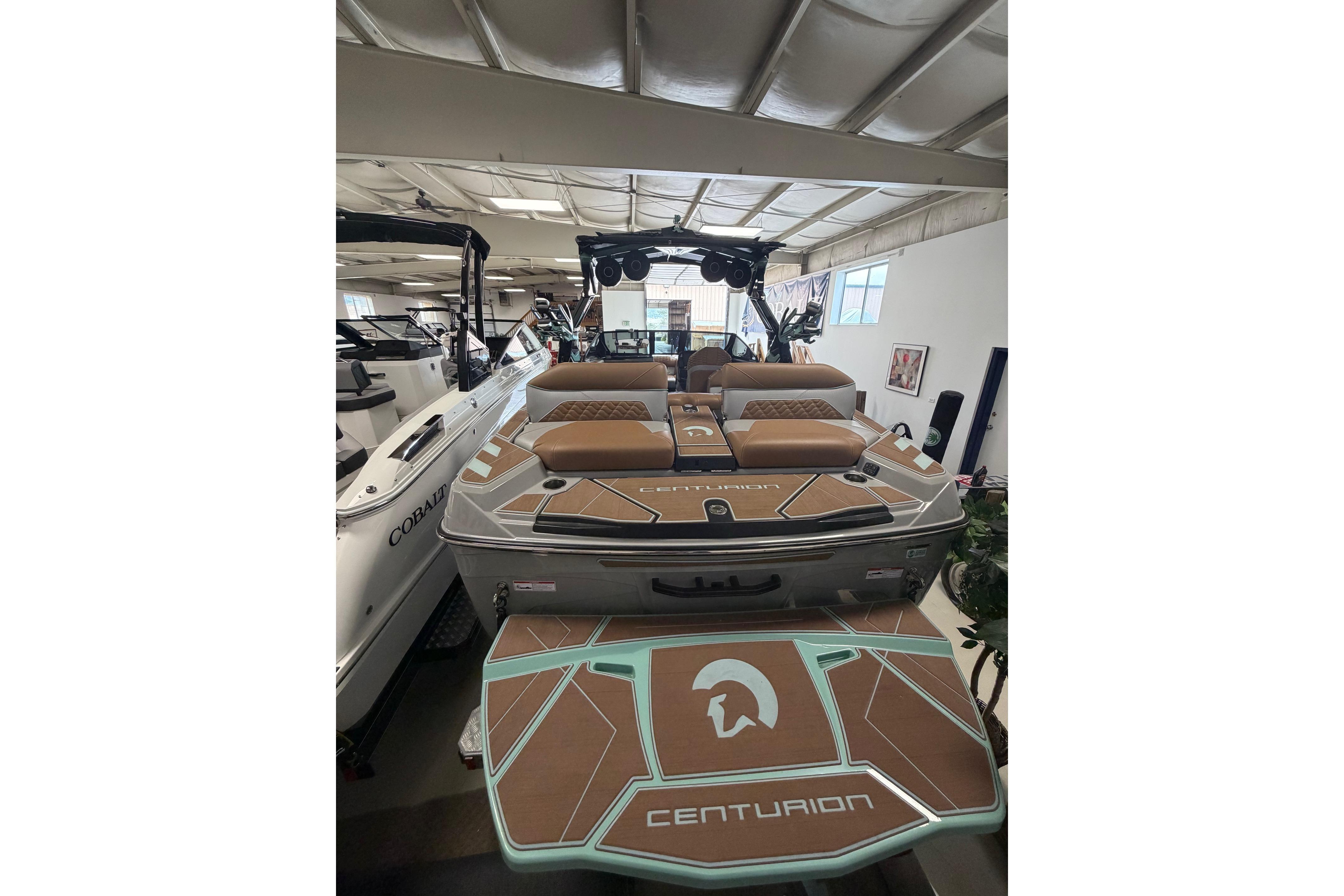 2025 Centurion Ri245 boat with stylish brown and teal deck in showroom.