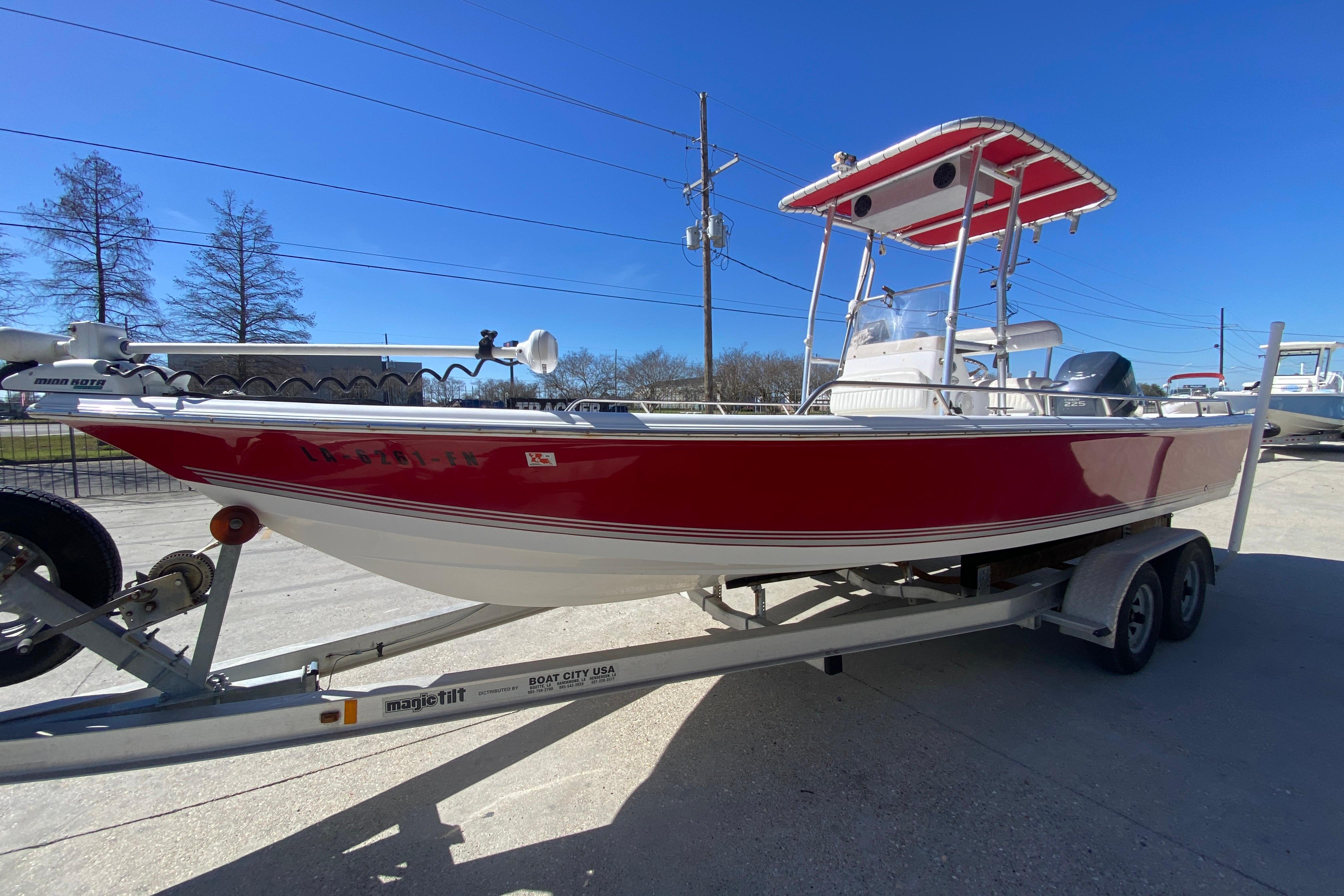 2005 Sea Pro SV2400CC Bay Boat in red on trailer, clear blue sky background.