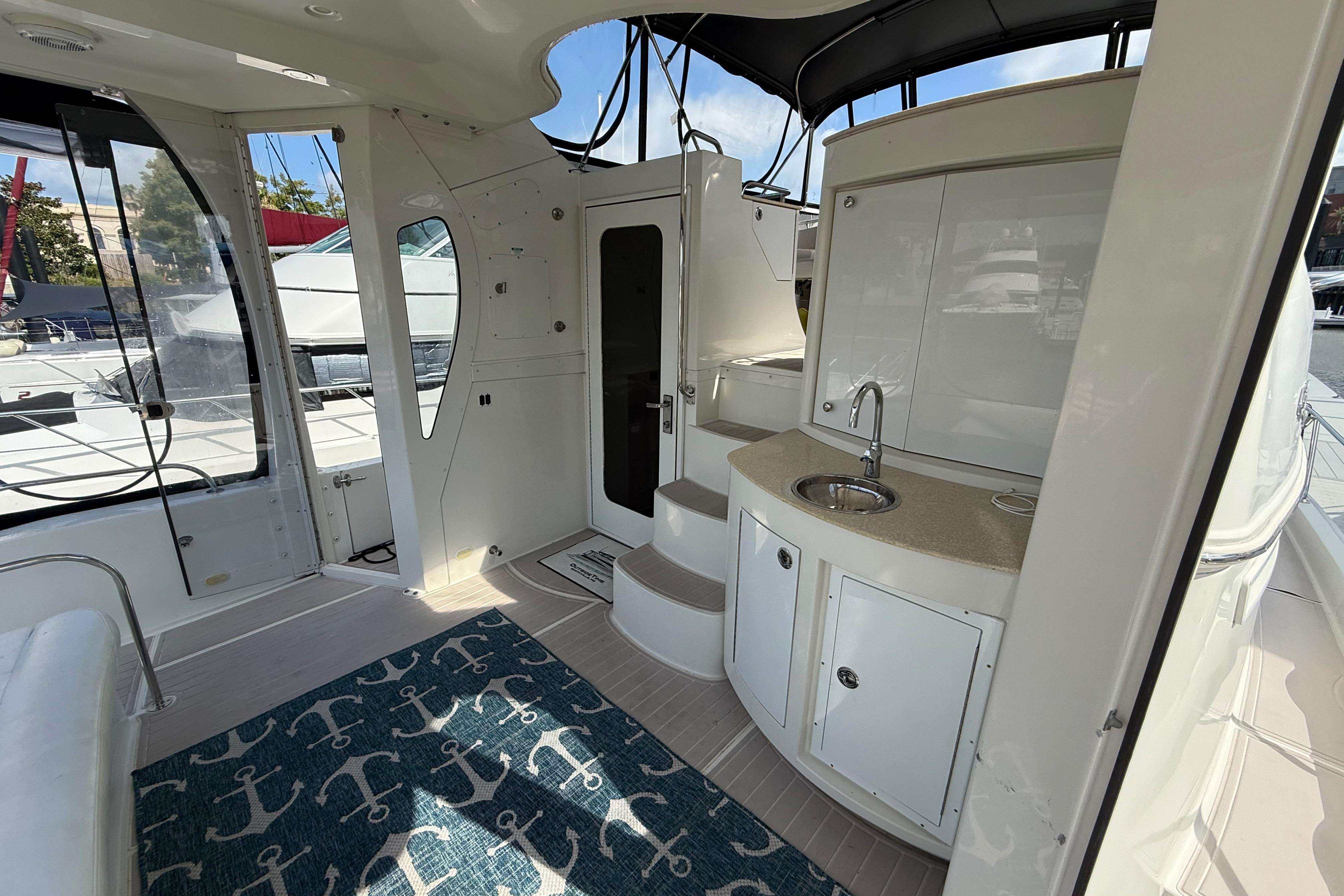 2006 Carver 43 Motor Yacht interior with kitchenette, sink, and nautical-themed rug.