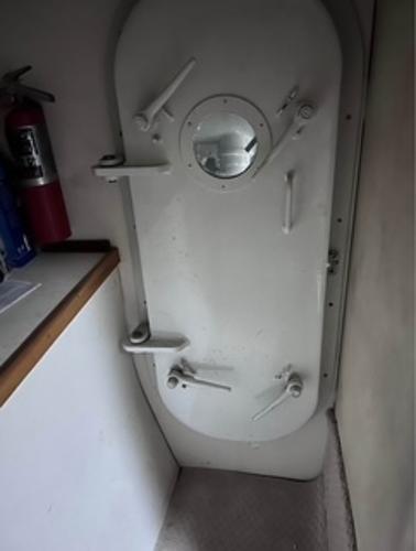 1986 Egg Harbor 60 Sportfisherman interior with a secure, white hatch door and fire extinguisher.