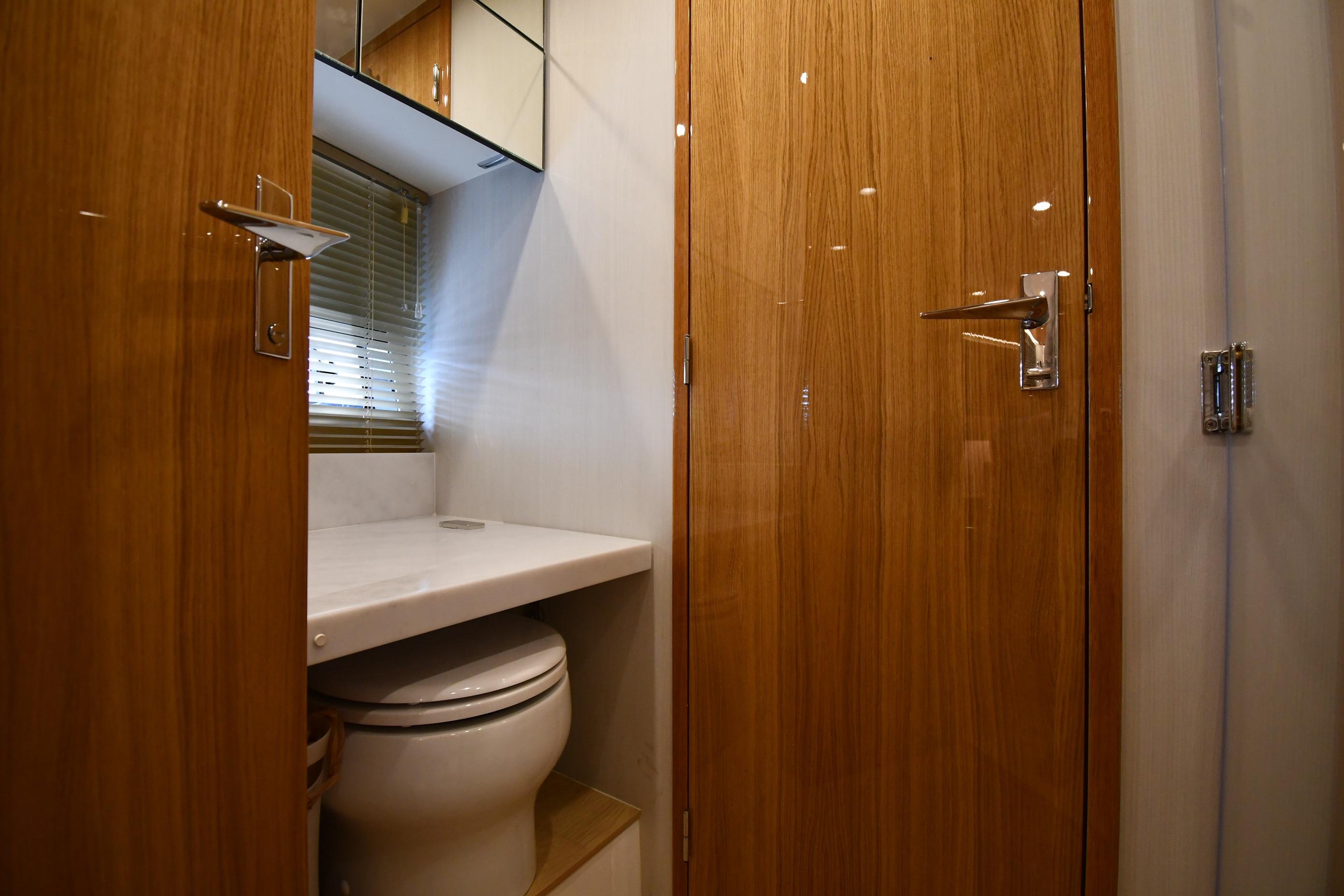 Luxurious bathroom interior of 2024 Fairline G50 Targa yacht with wooden doors and modern fixtures.