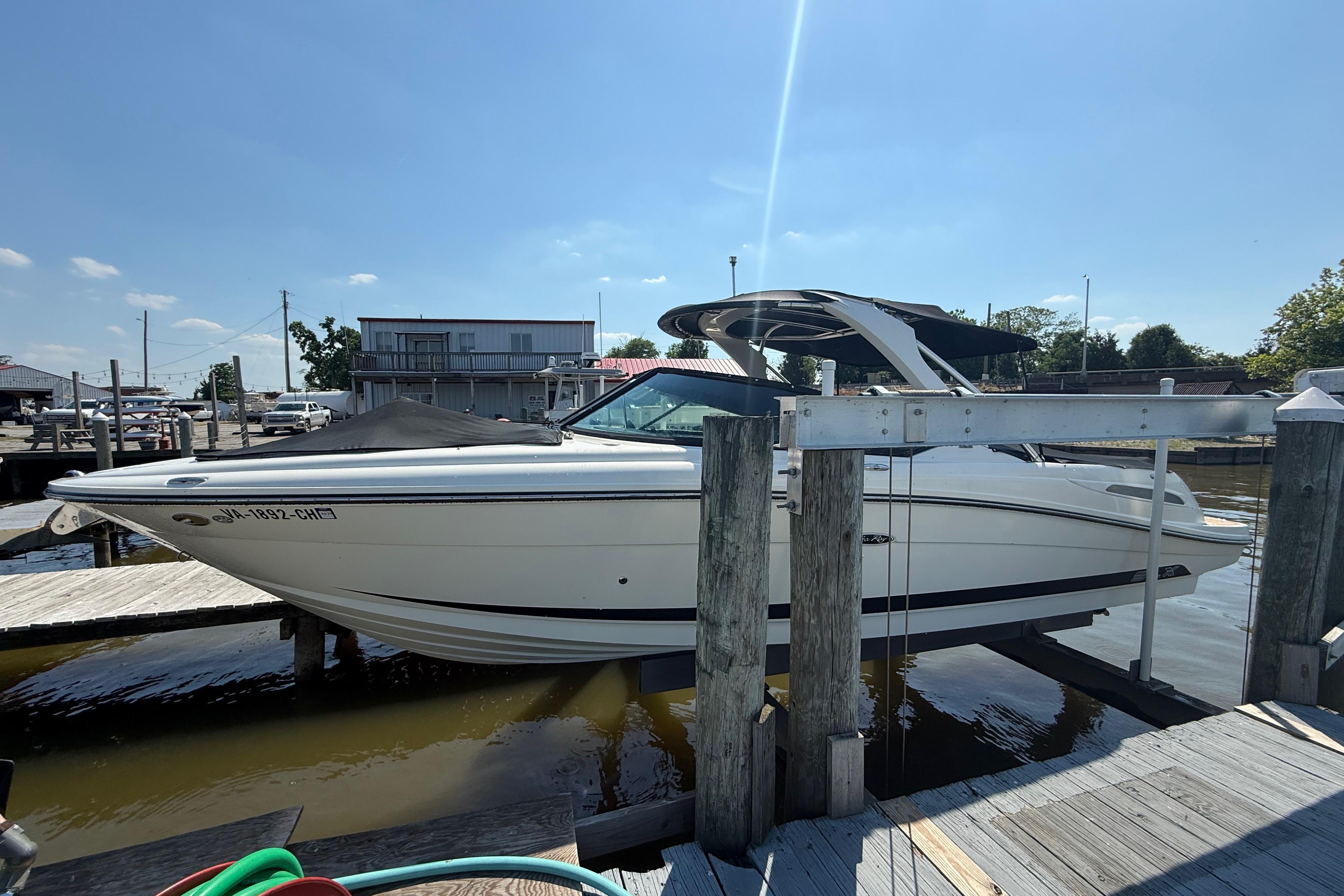 2011 Sea Ray 270 SLX boat docked at a marina under clear blue skies.