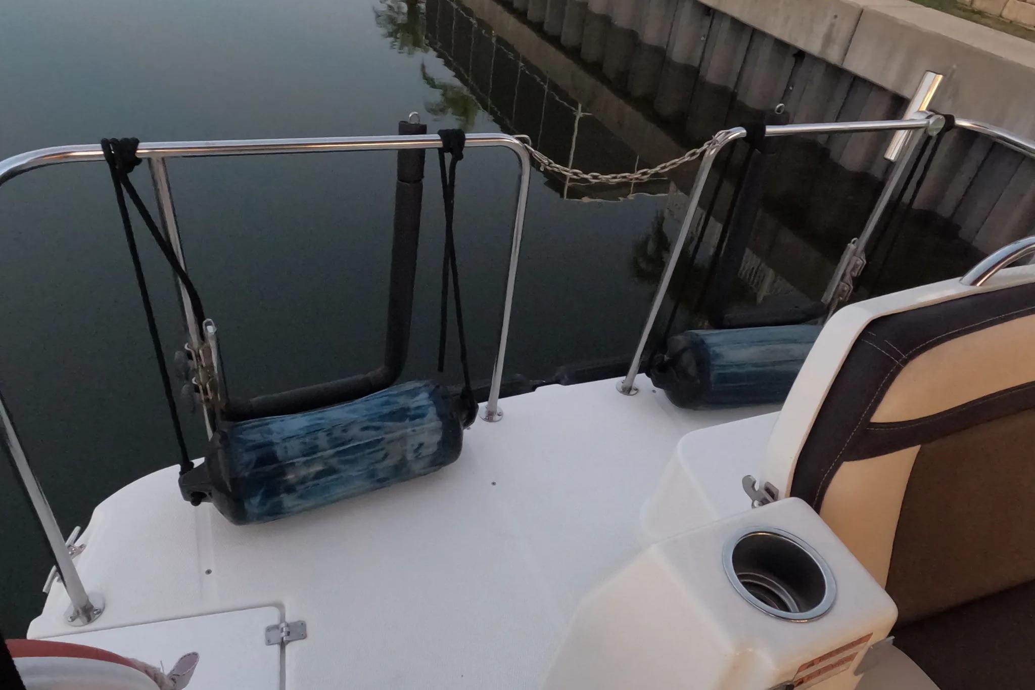 2015 Ranger Tugs R-29 S boat stern with fenders and seating near dock.